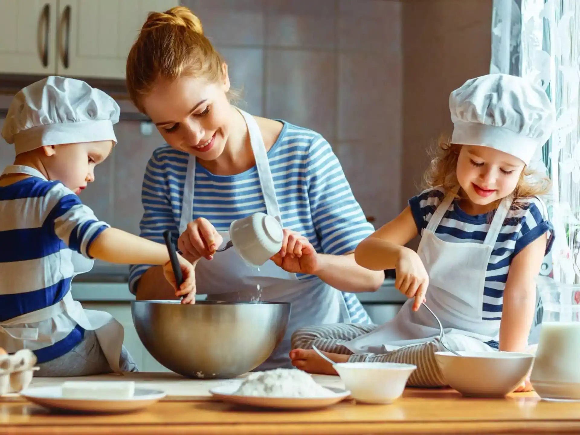 a person and two children cooking