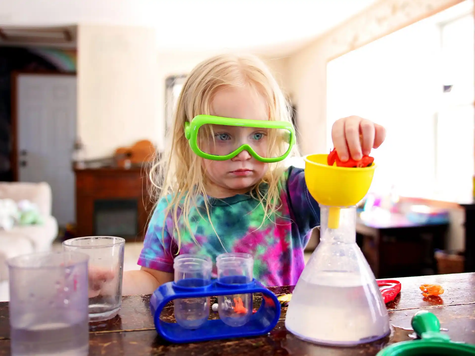a little girl with a plastic cup and a plastic bottle
