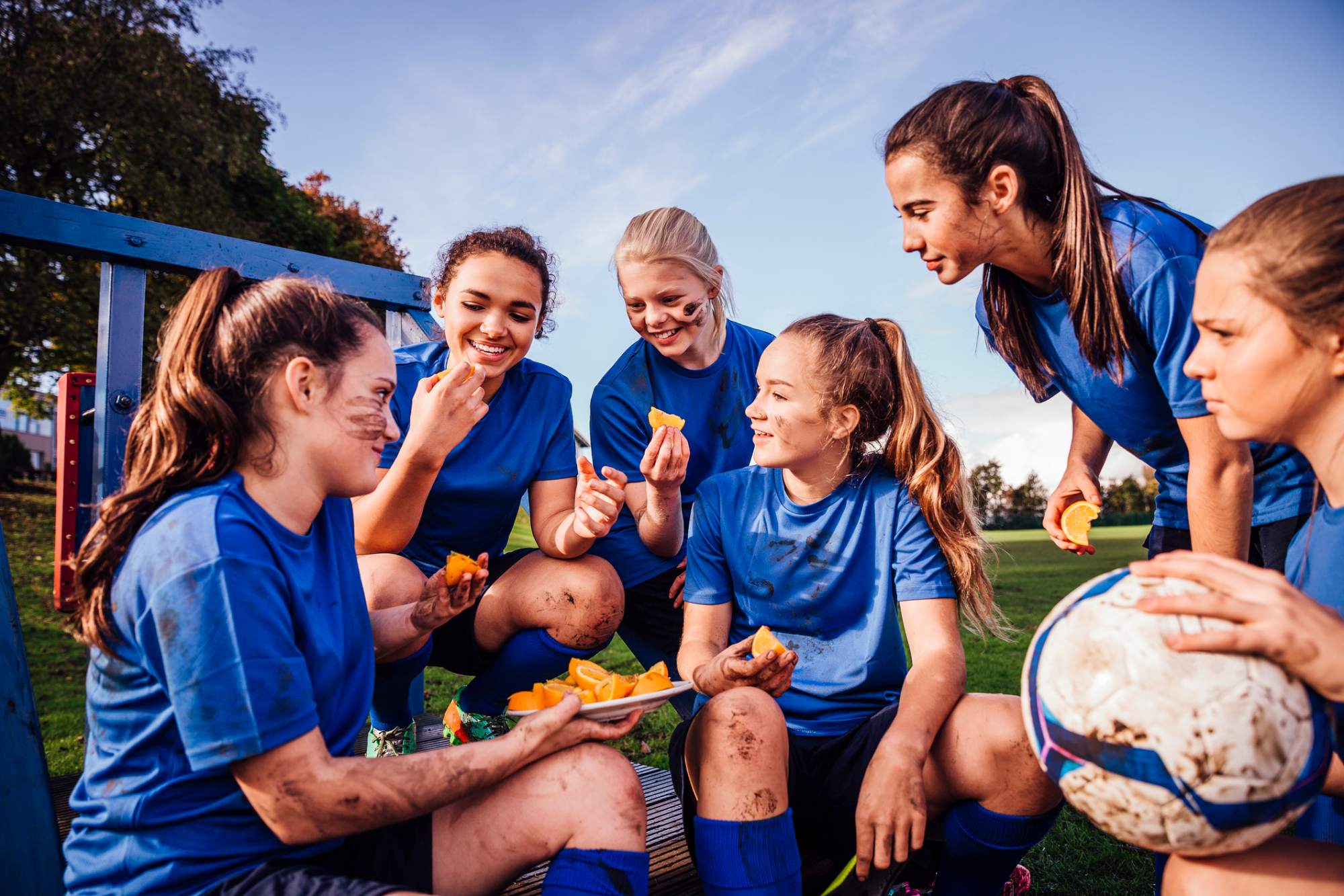 a group of people sitting on a bench eating food