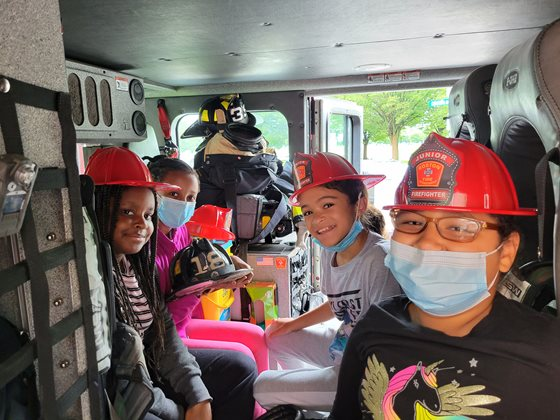 a group of people wearing helmets and sitting in a vehicle