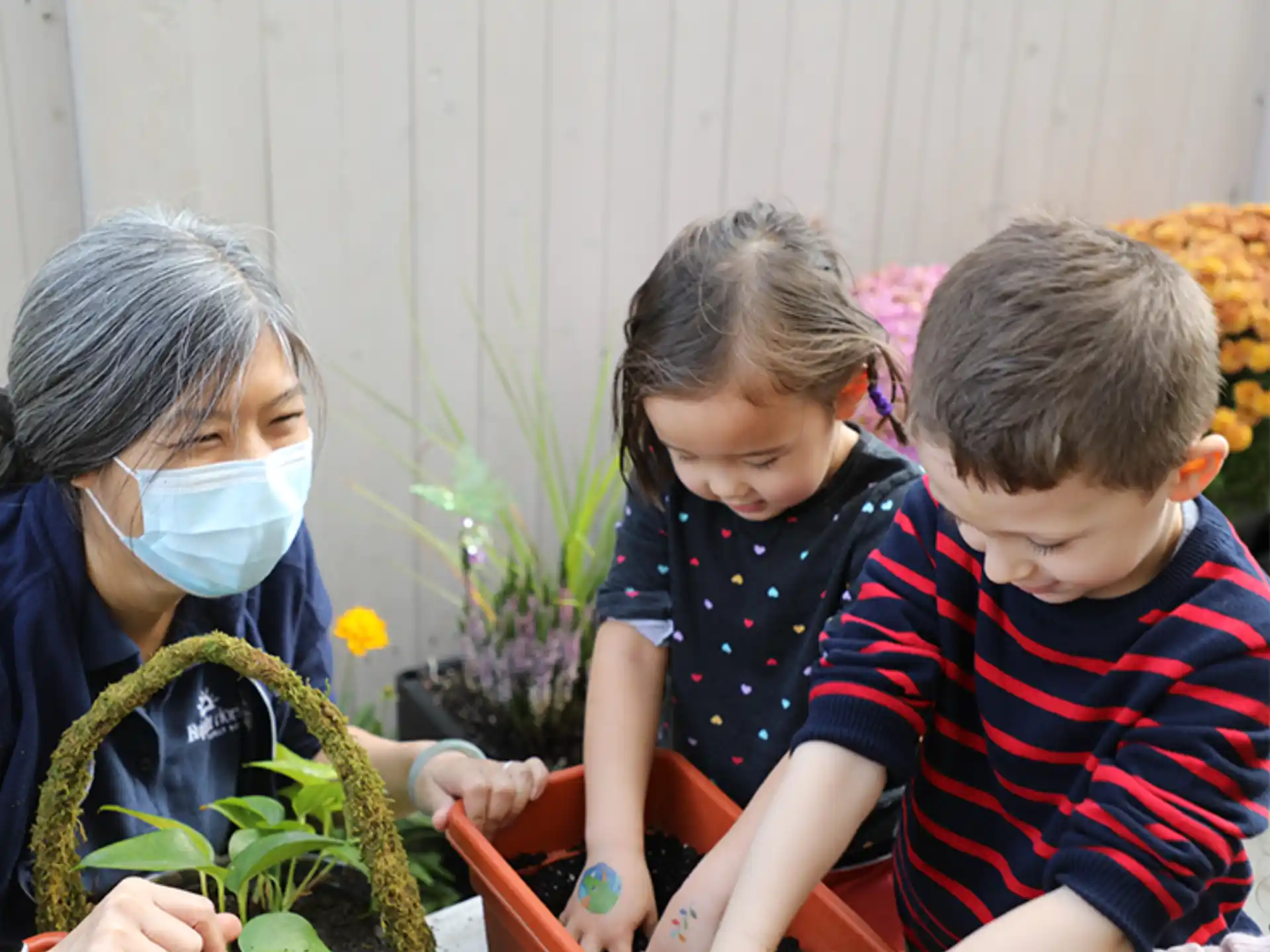 a person and a child looking at a plant