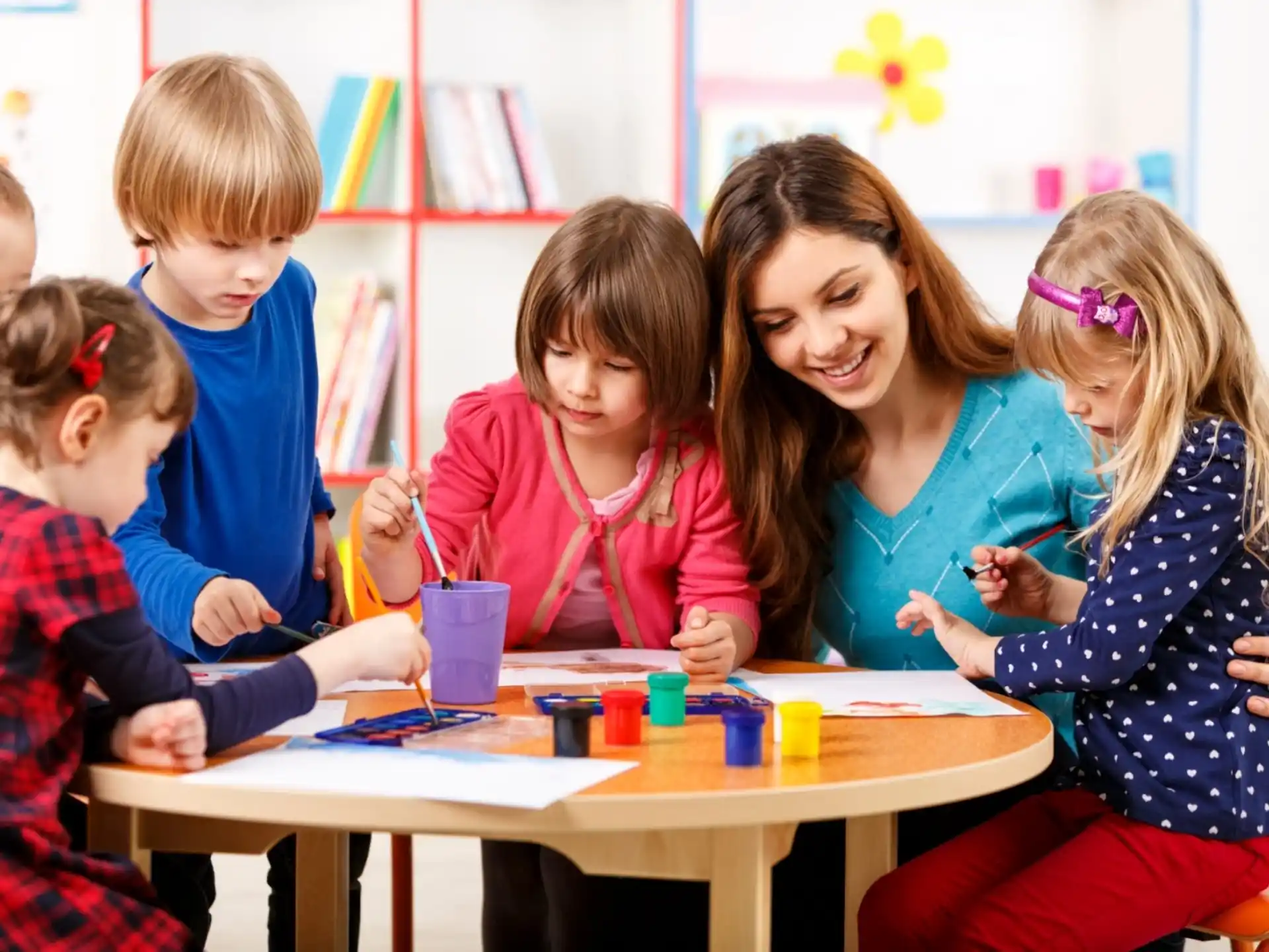 a person and several children sitting at a table
