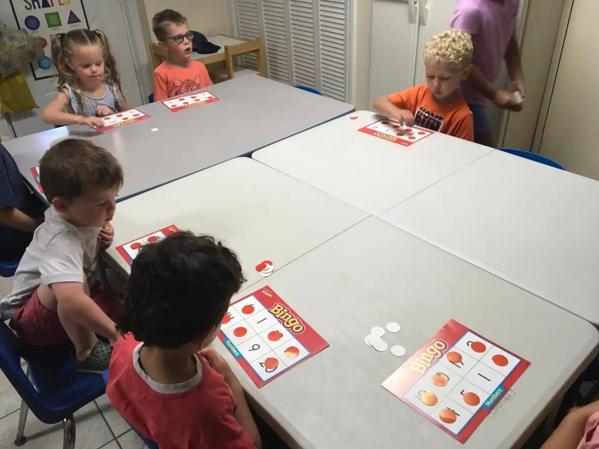 a group of children sitting around a table playing a board game