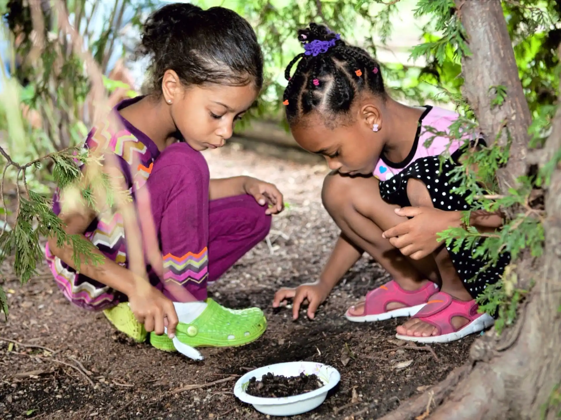 a person and a child sitting in the dirt