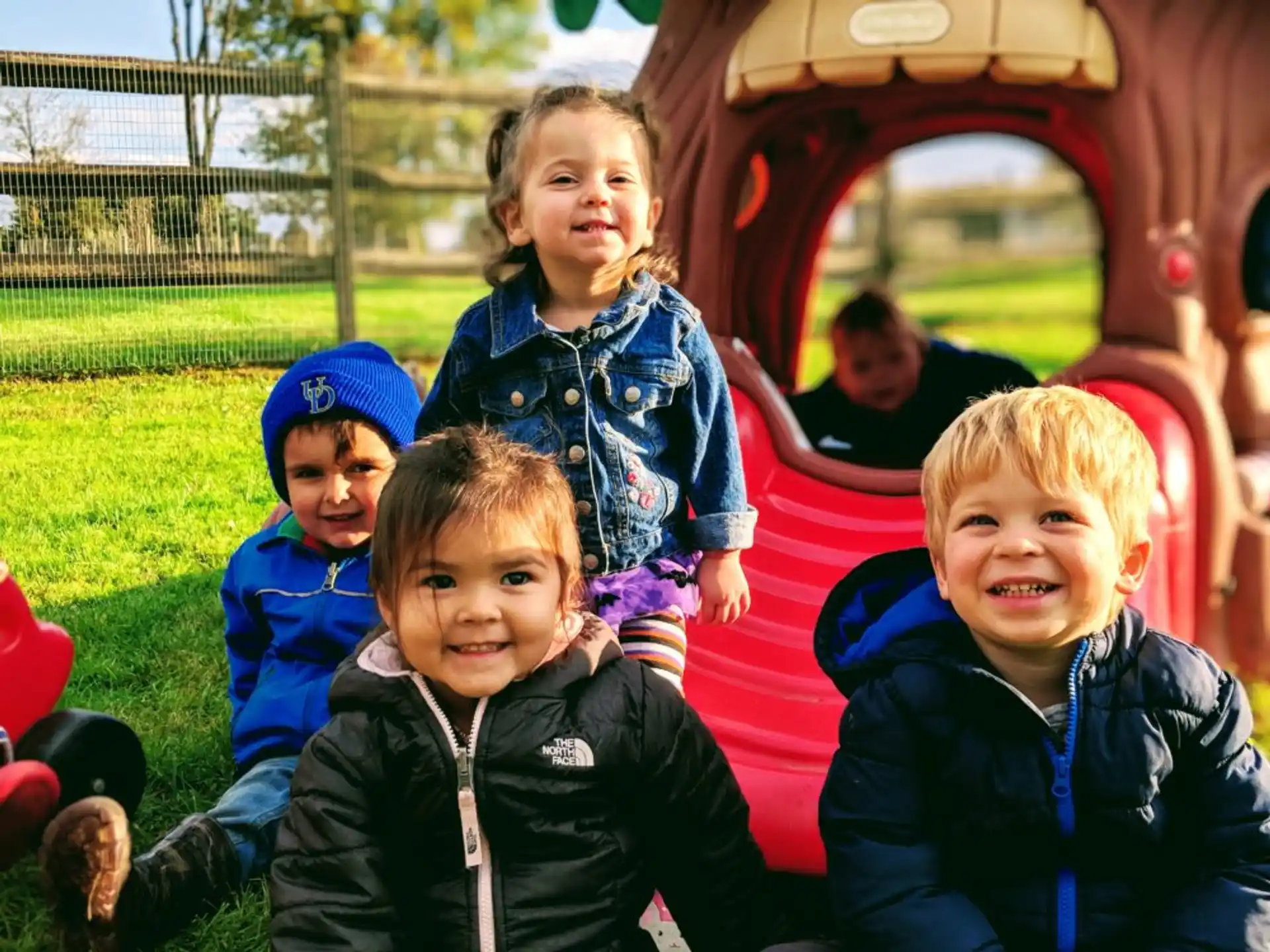 a group of children sitting on a red slide