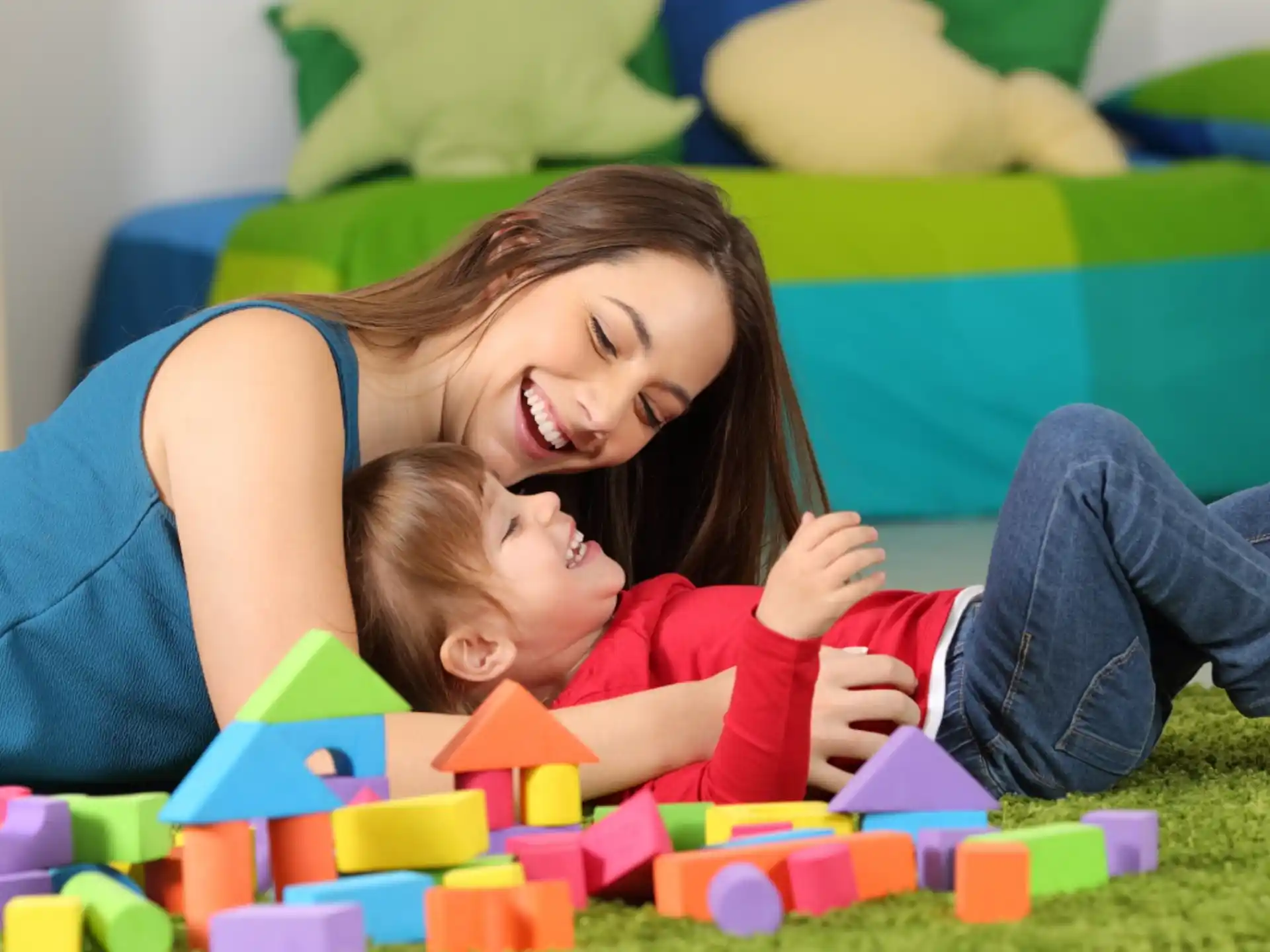 a person and a baby playing with blocks
