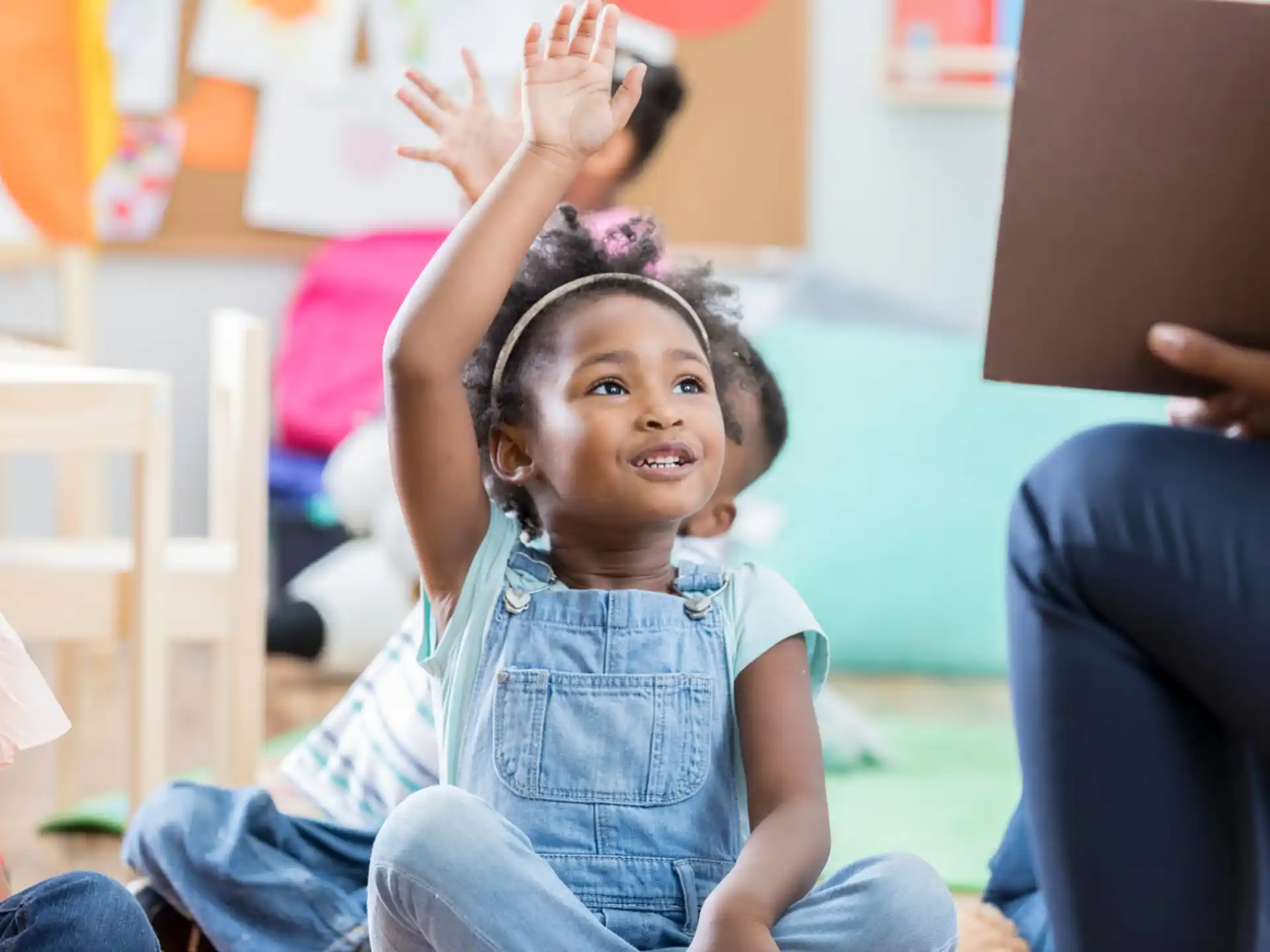 a young girl raising her hands