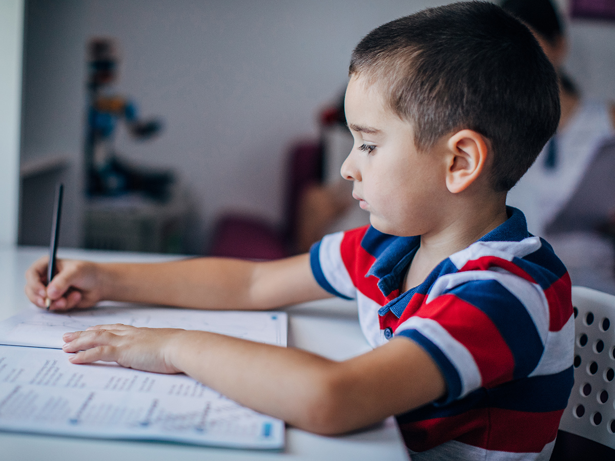 a young boy writing on a paper
