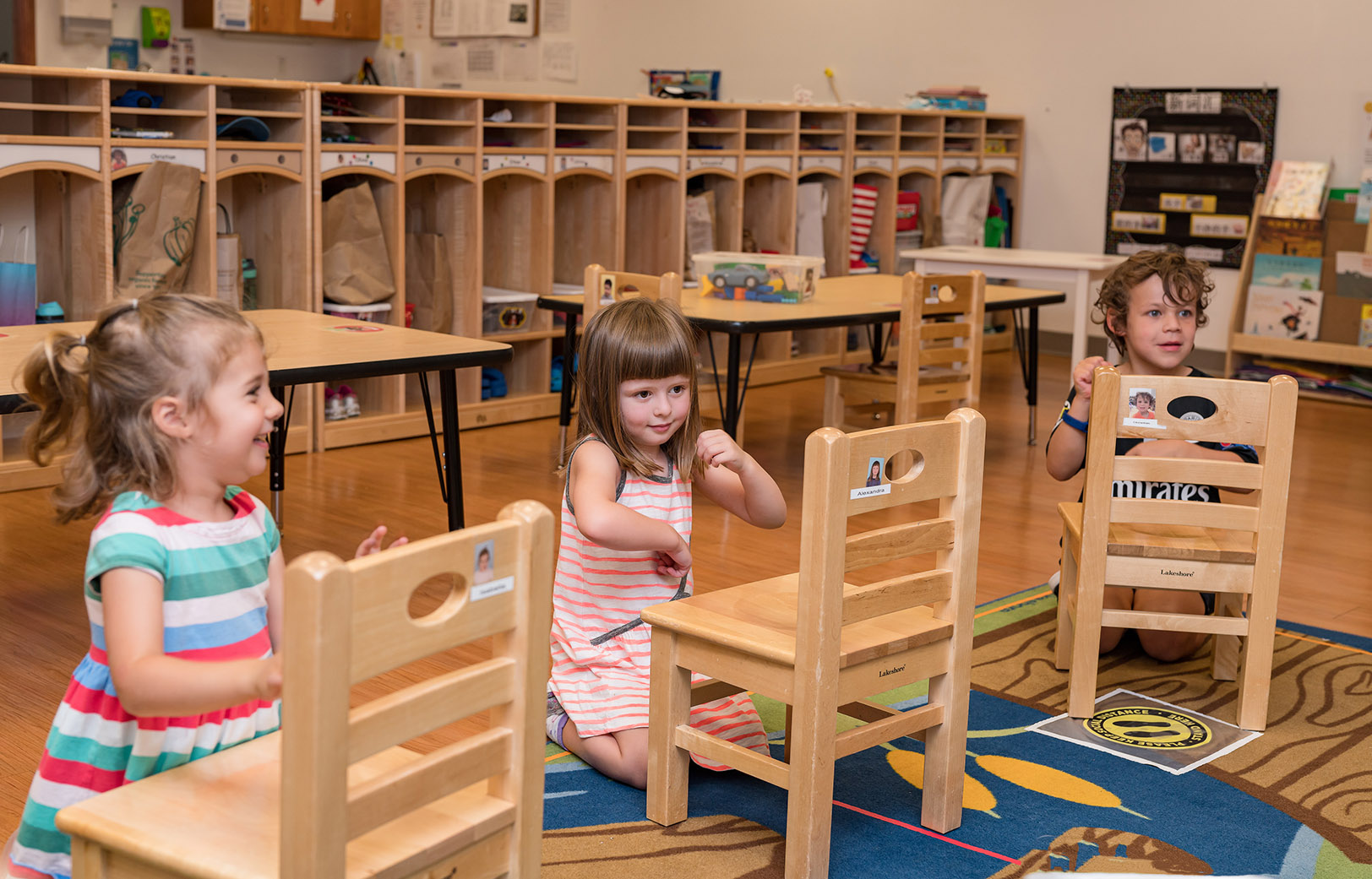 a group of children sitting at a table in a classroom