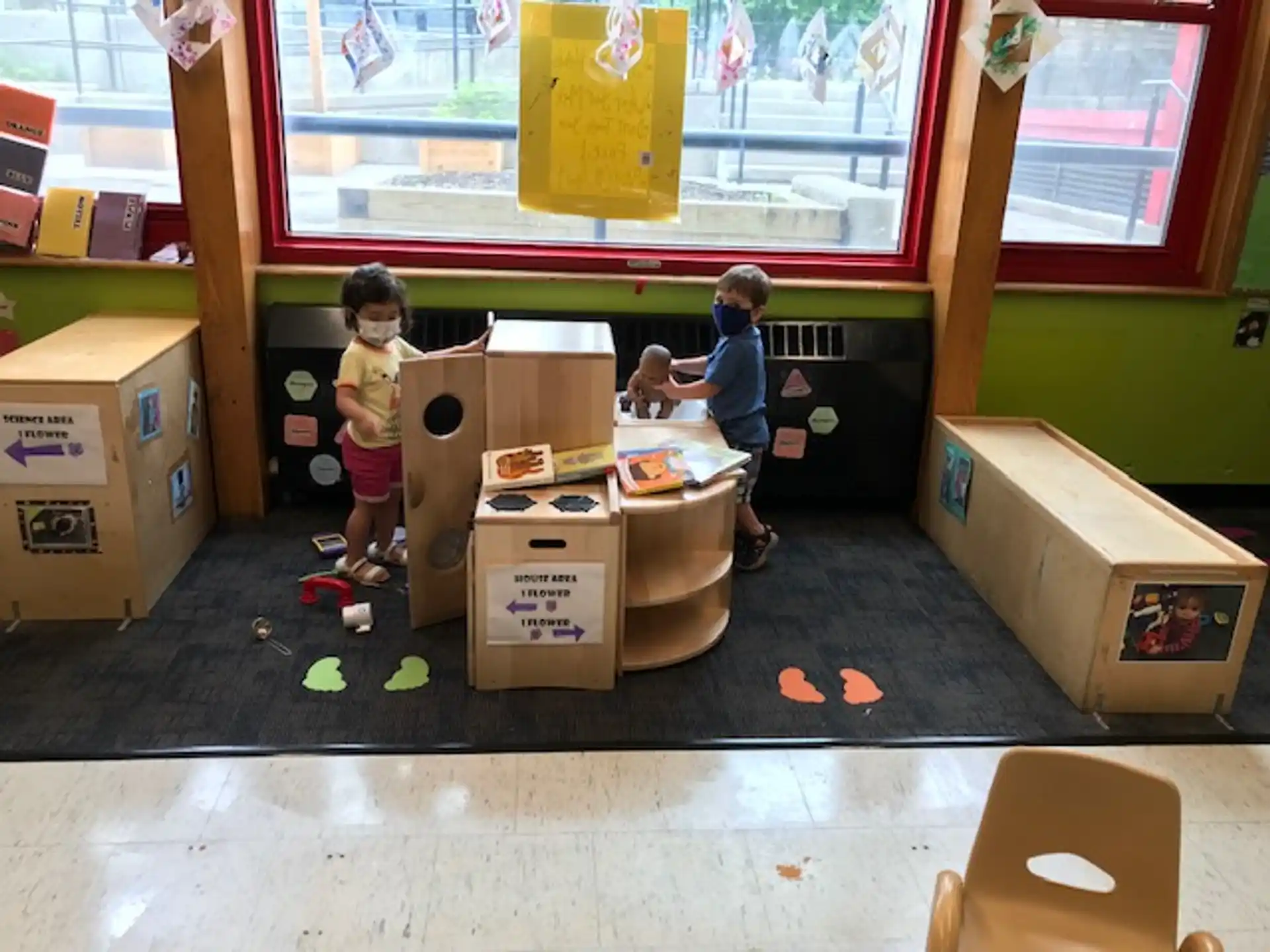 a group of kids in a room with boxes and a window