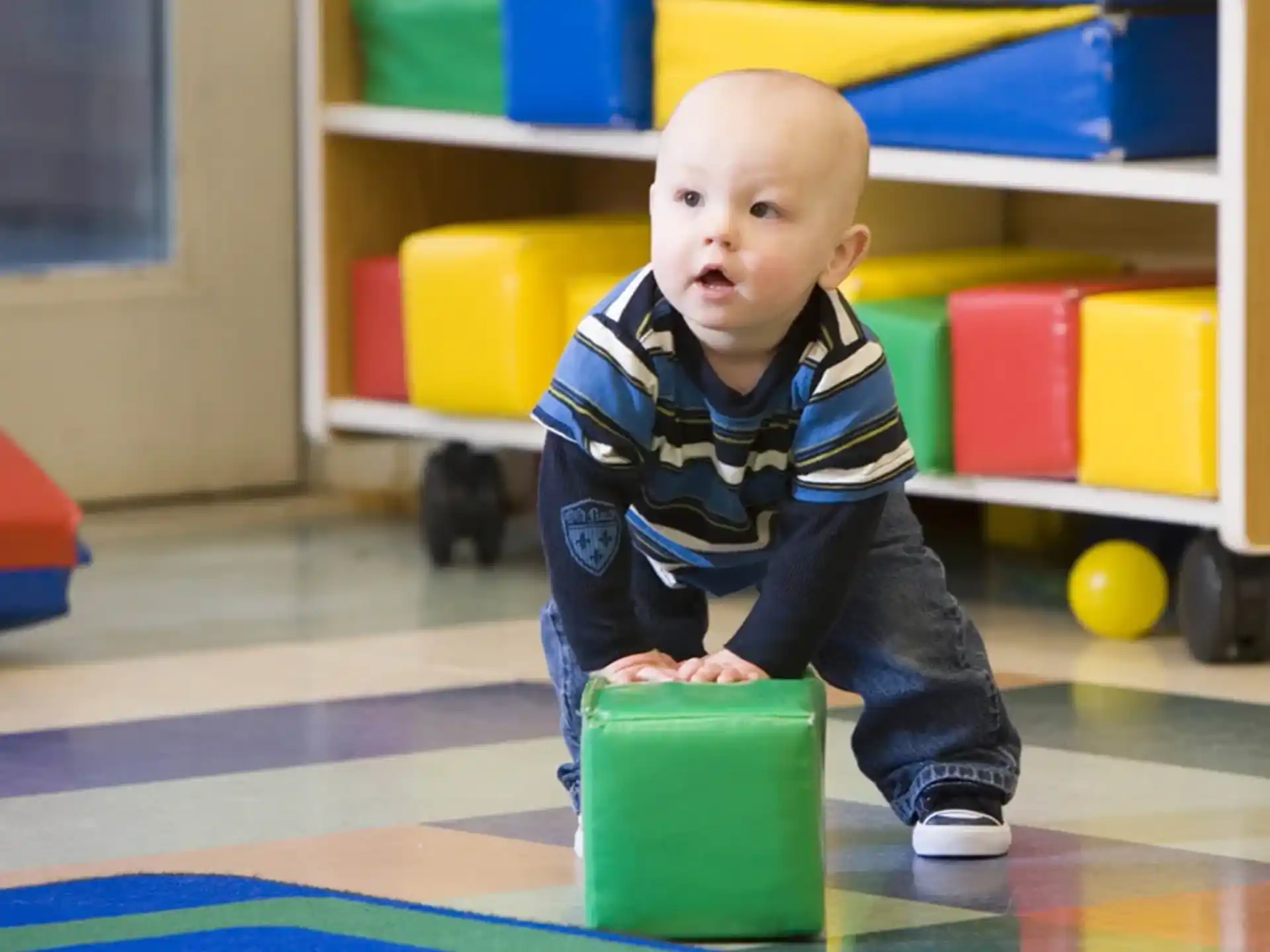 a baby sitting on a toy