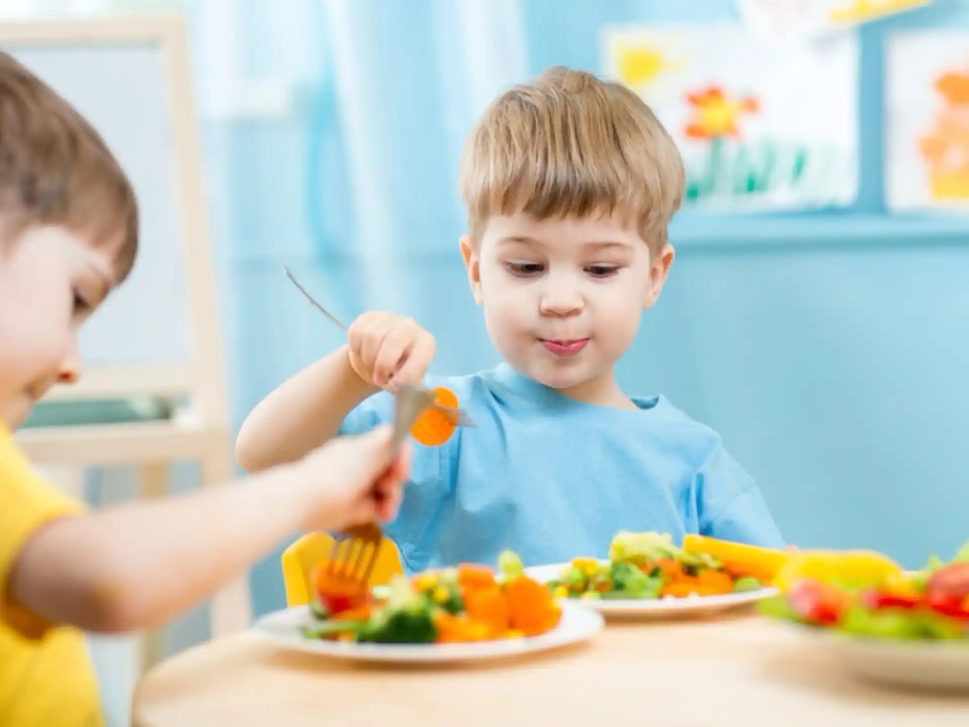 a couple of boys eating at a table