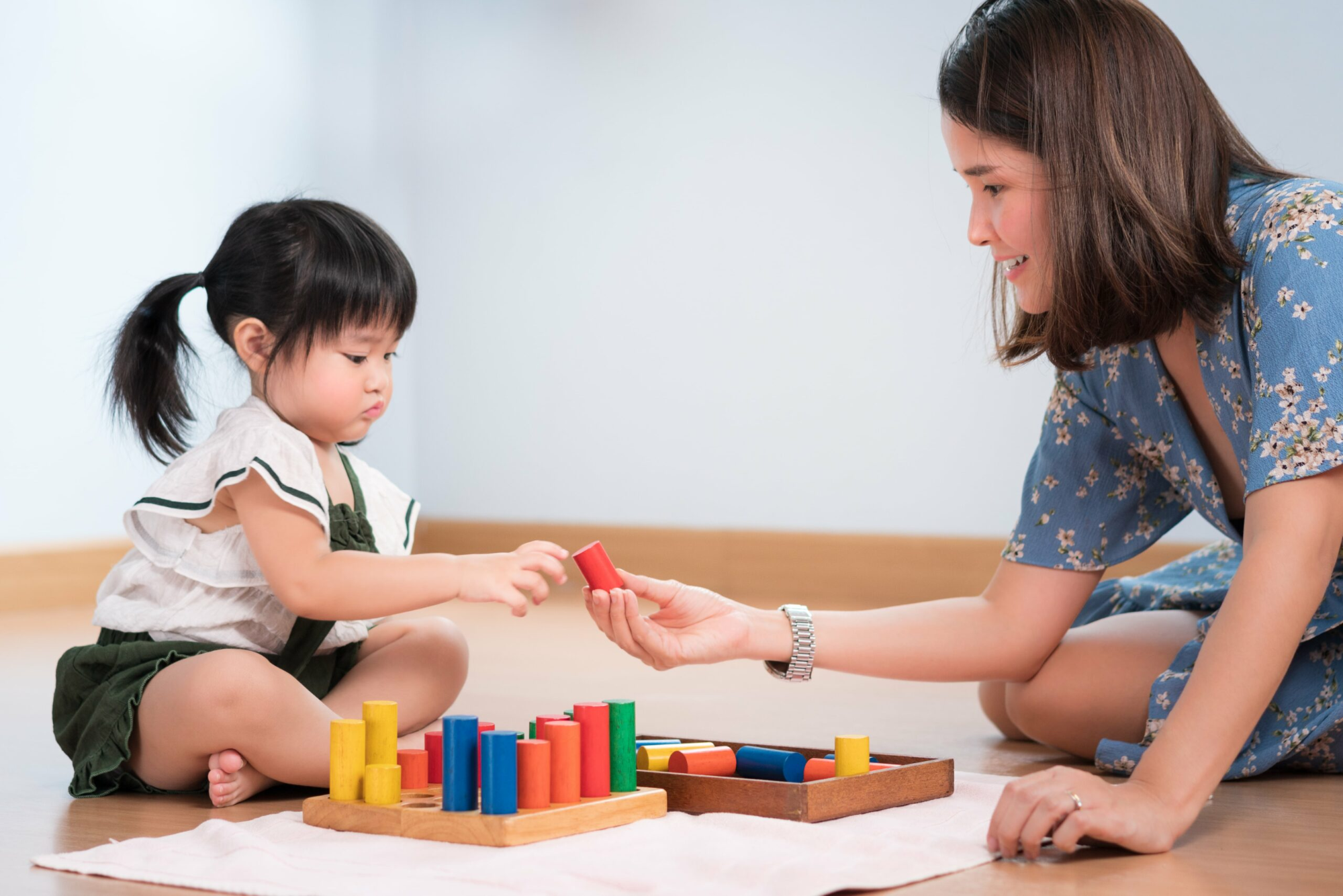 a person and a child playing with blocks