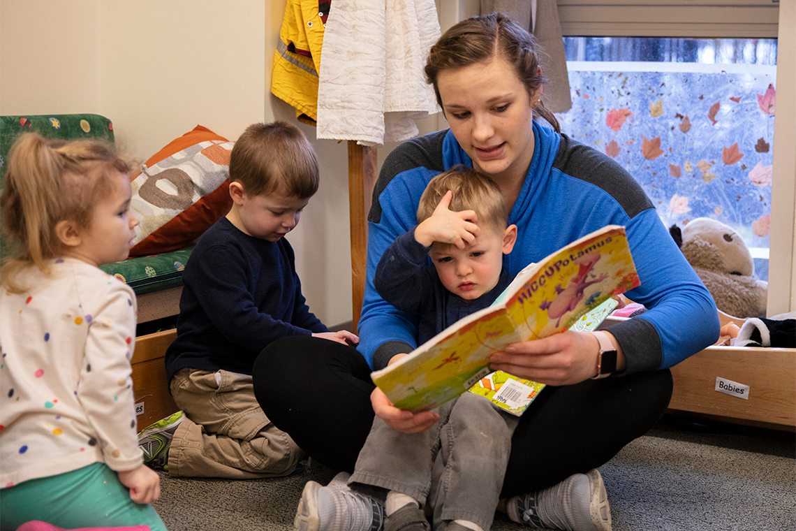 a person reading a book to a couple of children