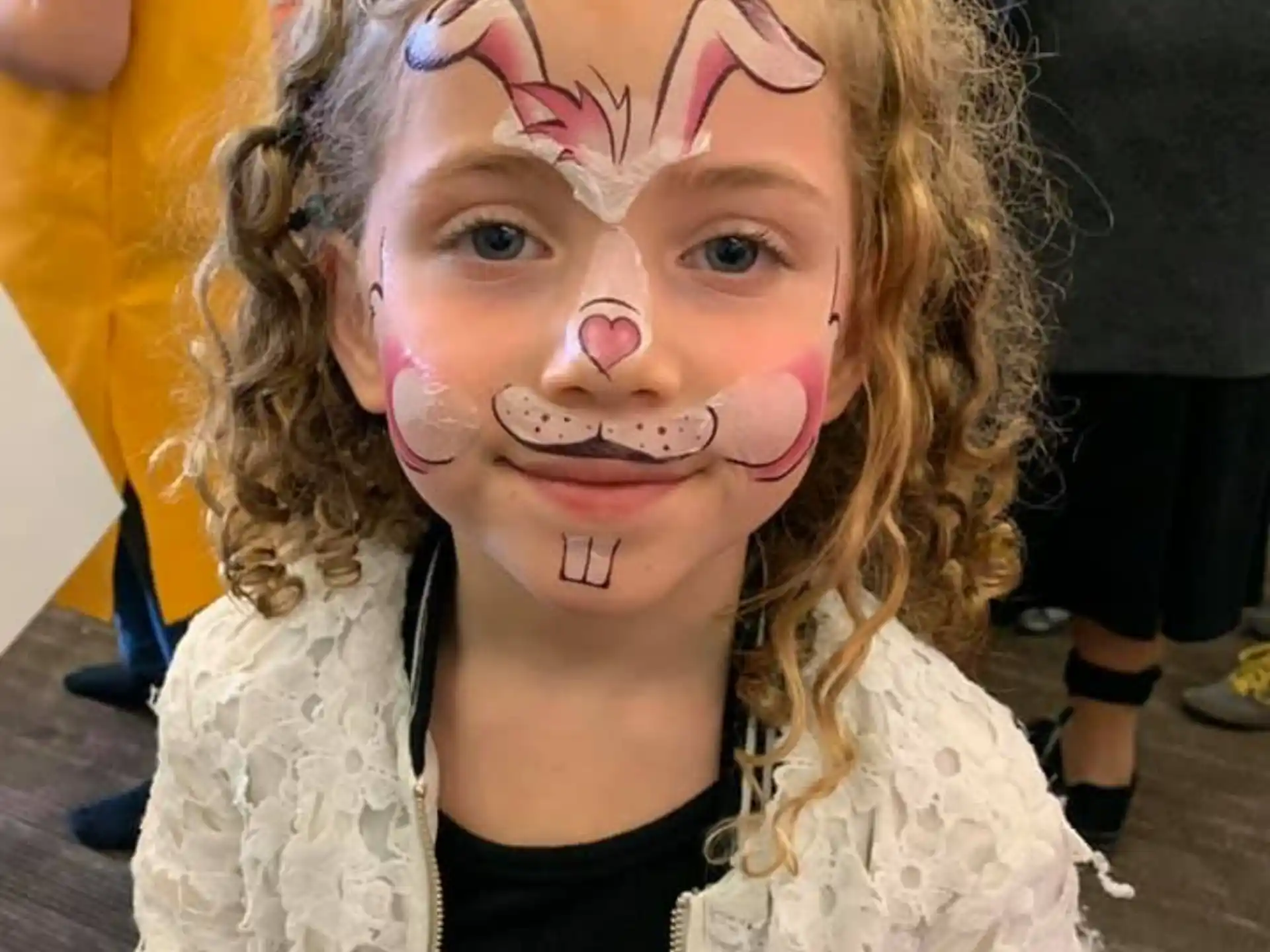 a girl with pink paint on her face