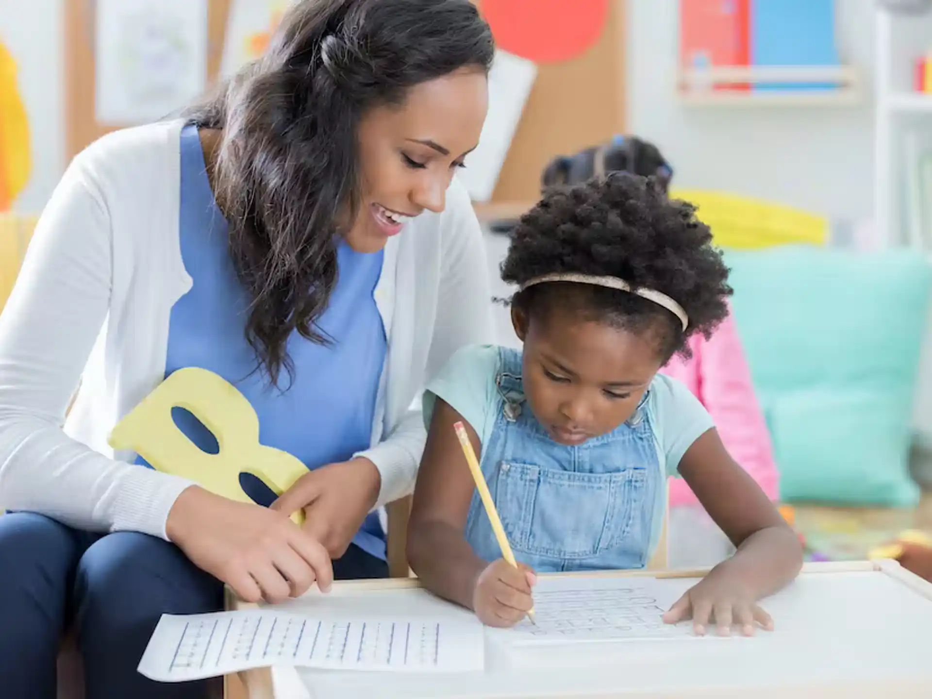 a person and a child writing on a paper