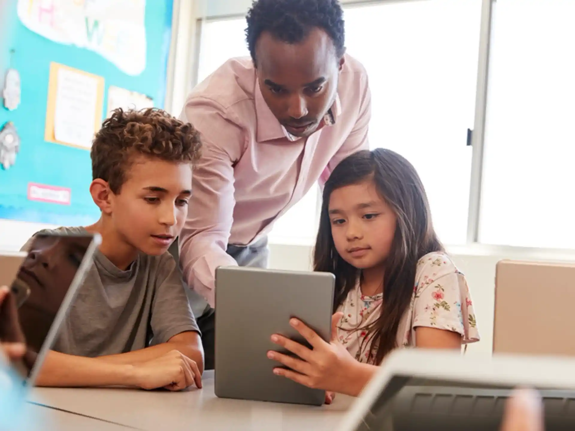 a group of people looking at a laptop