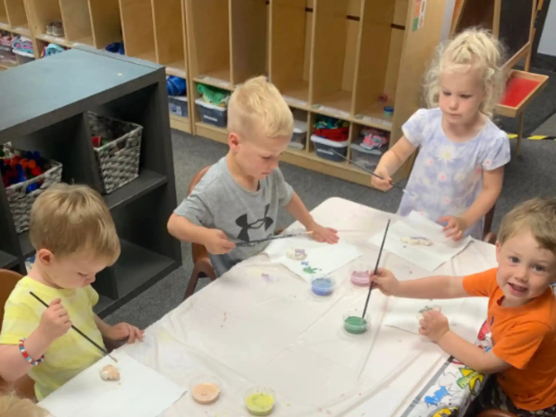 a group of children sitting around a table