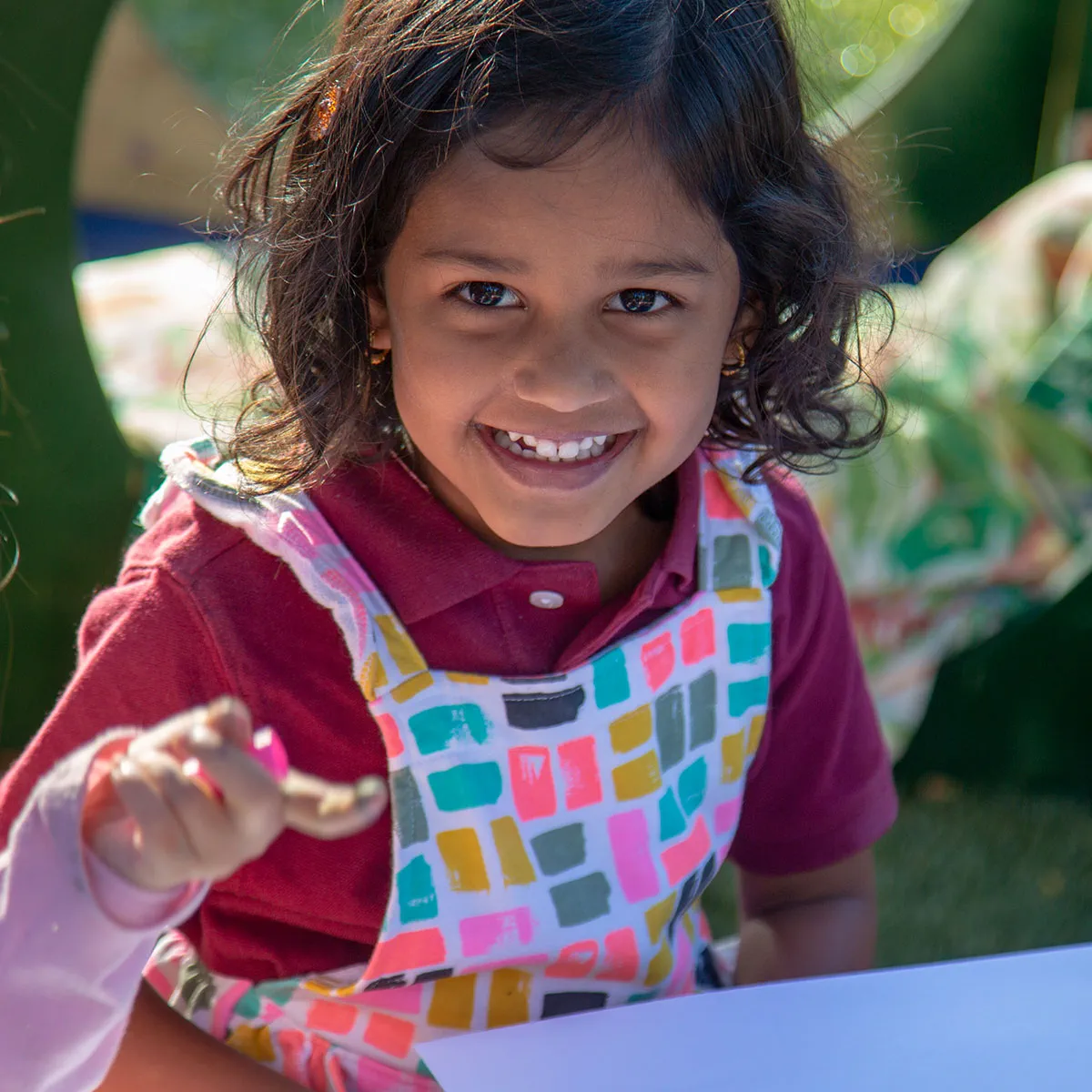 a girl smiling and holding a spoon