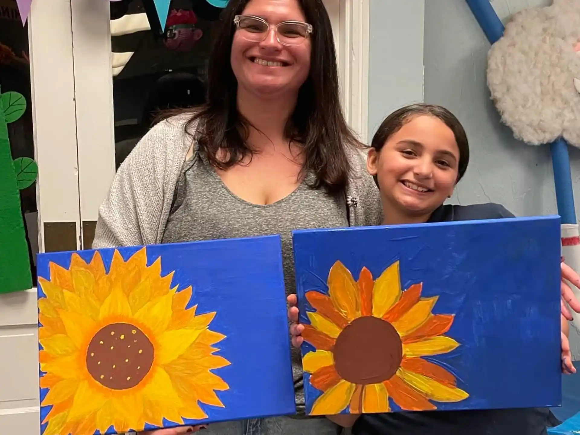 a couple of women holding paintings