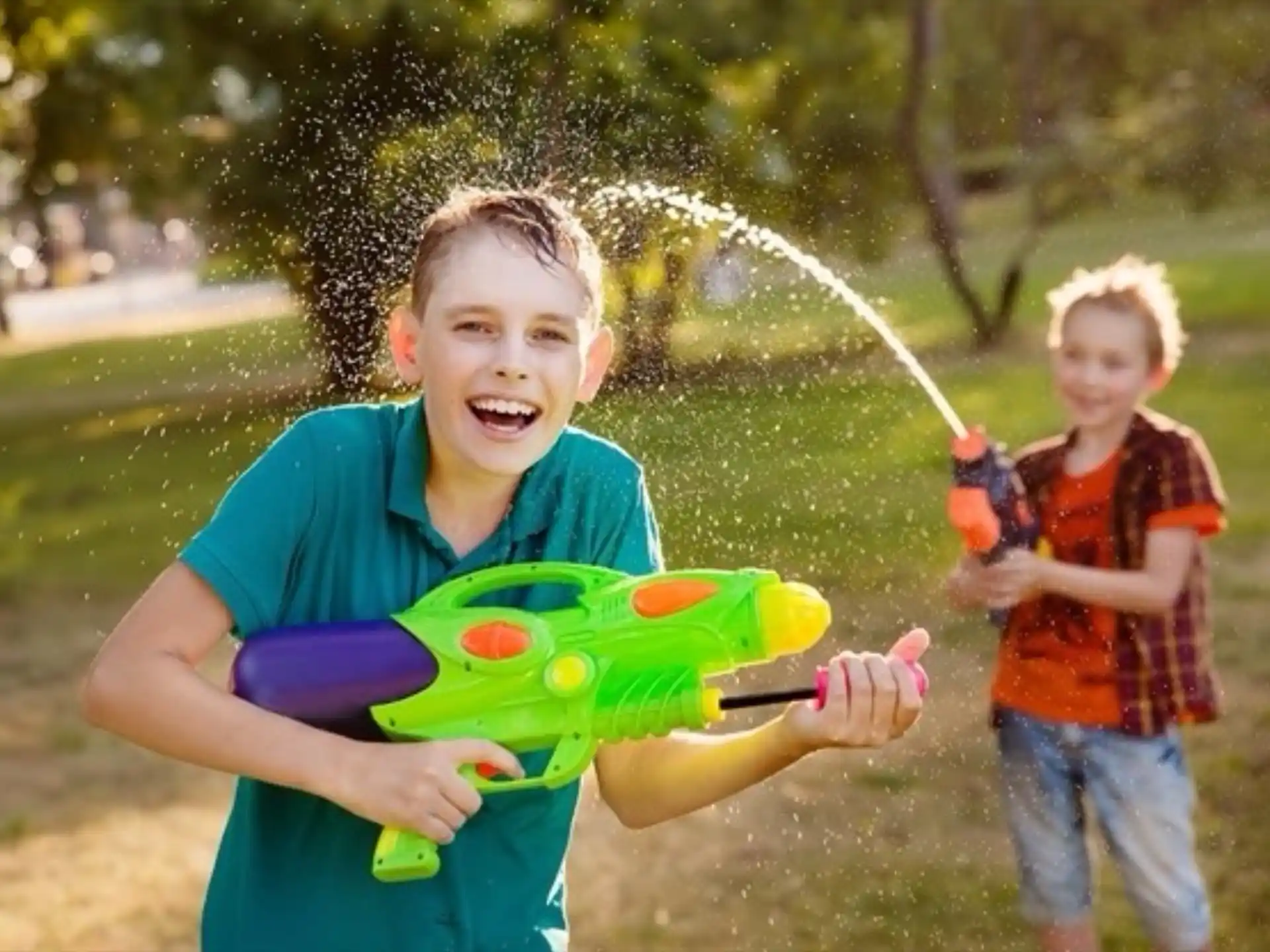 a boy holding a toy gun next to a boy holding a toy gun