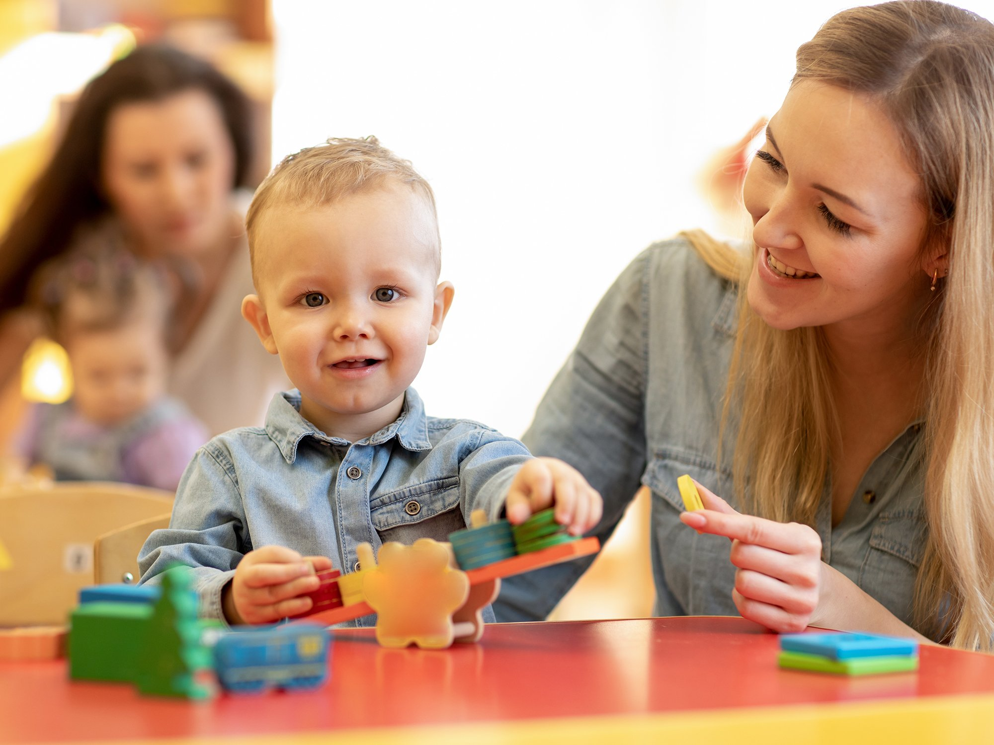 a person and a baby playing with toys