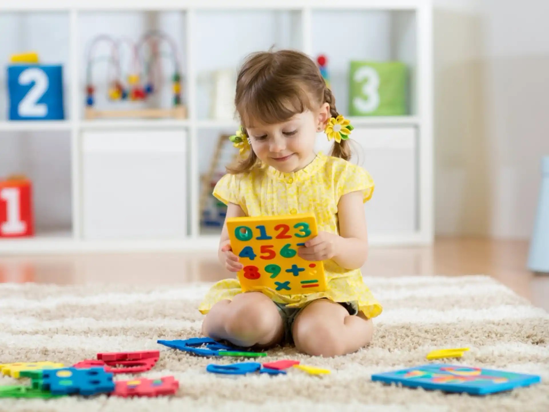 a girl sitting on the floor reading a book