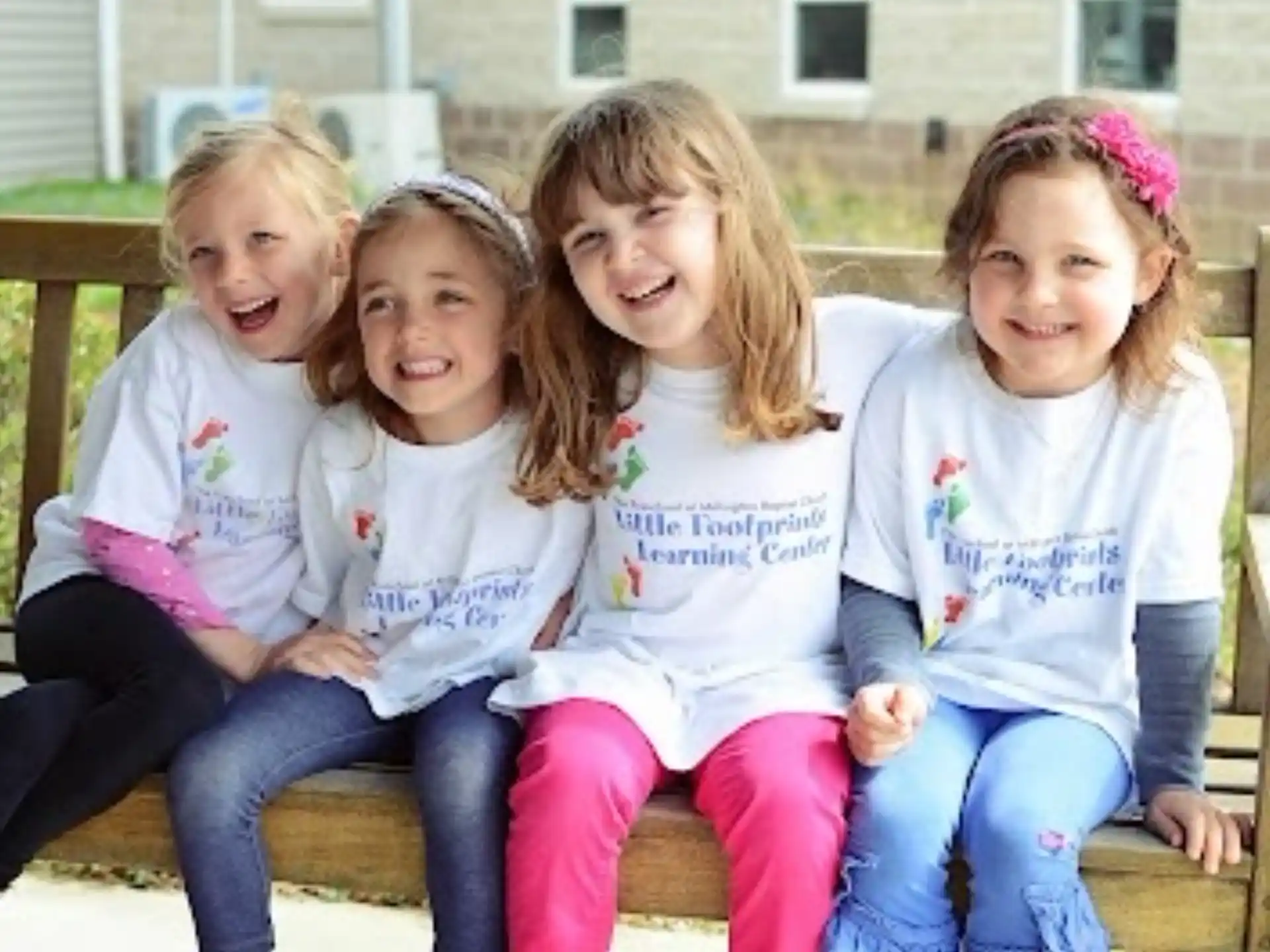 a group of girls sitting on a bench
