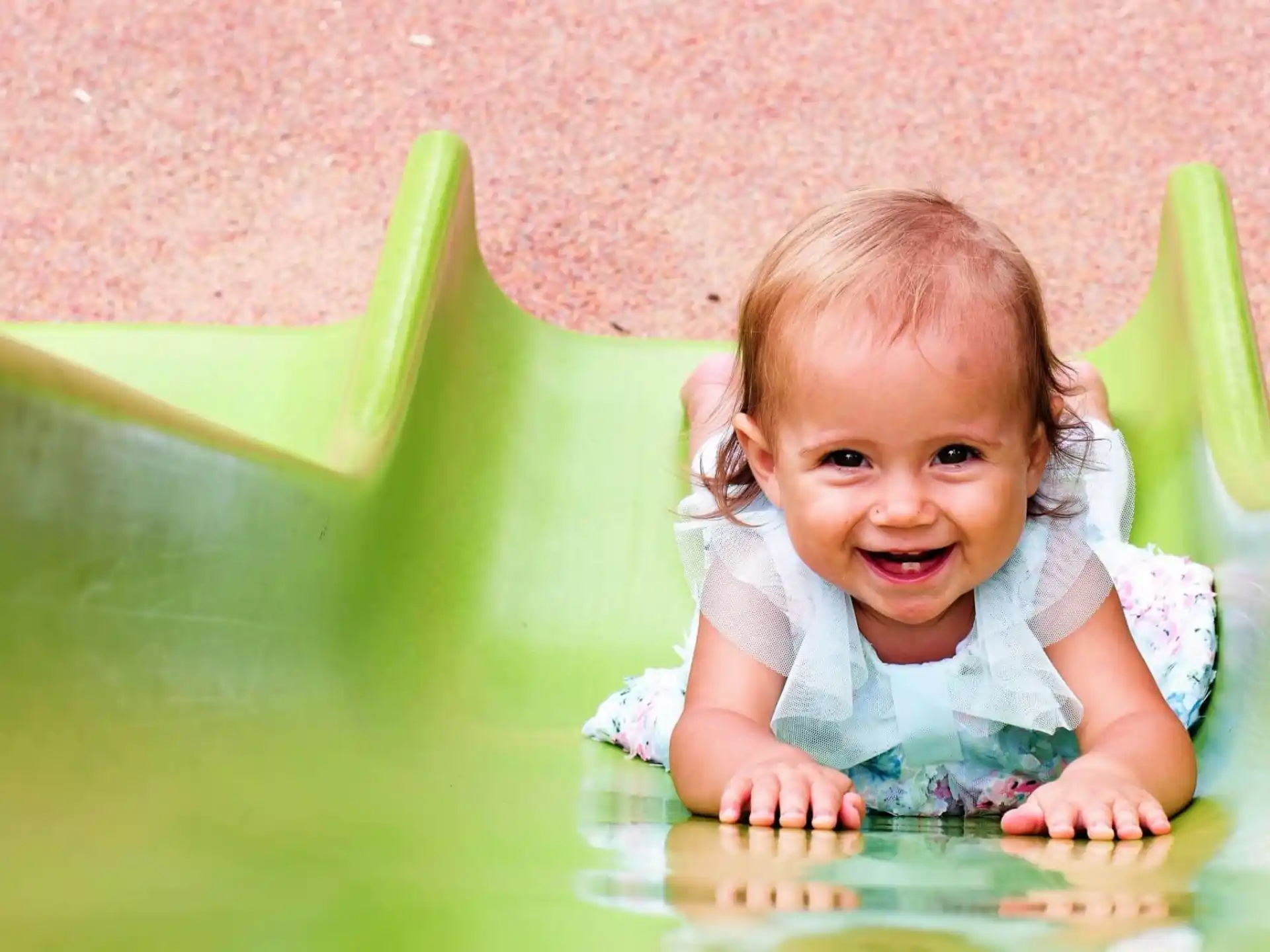 a baby crawling on a green surface
