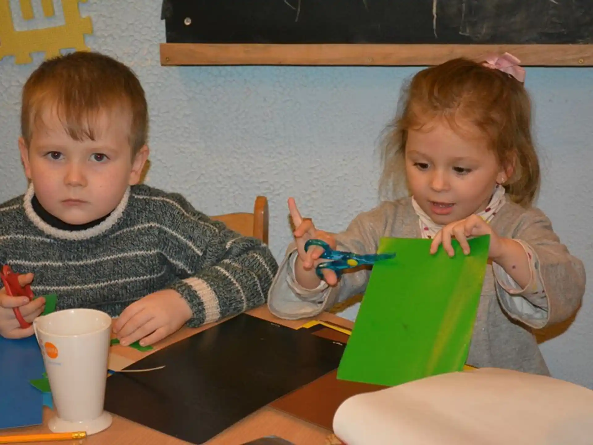 a couple of kids sit at a table