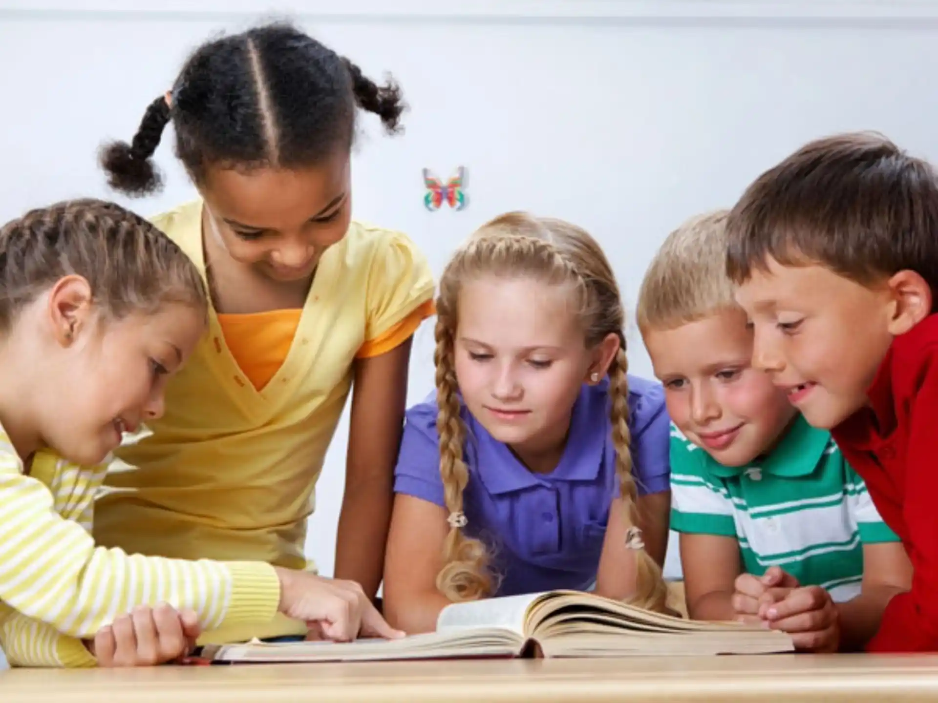 a group of children looking at a book