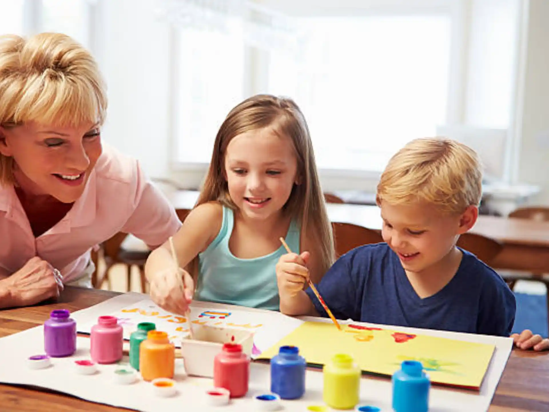 a person and two children painting