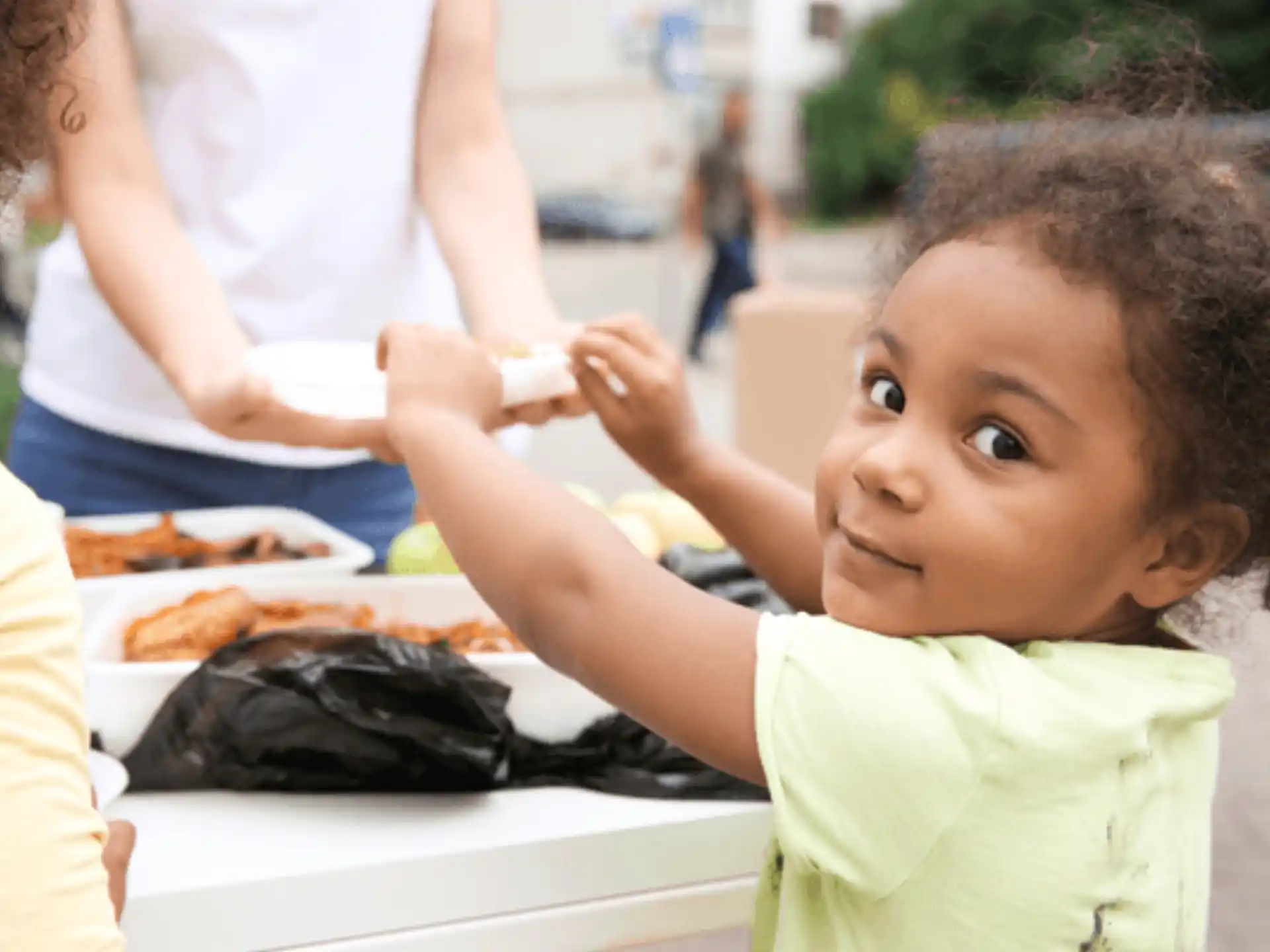 a child getting food from a table