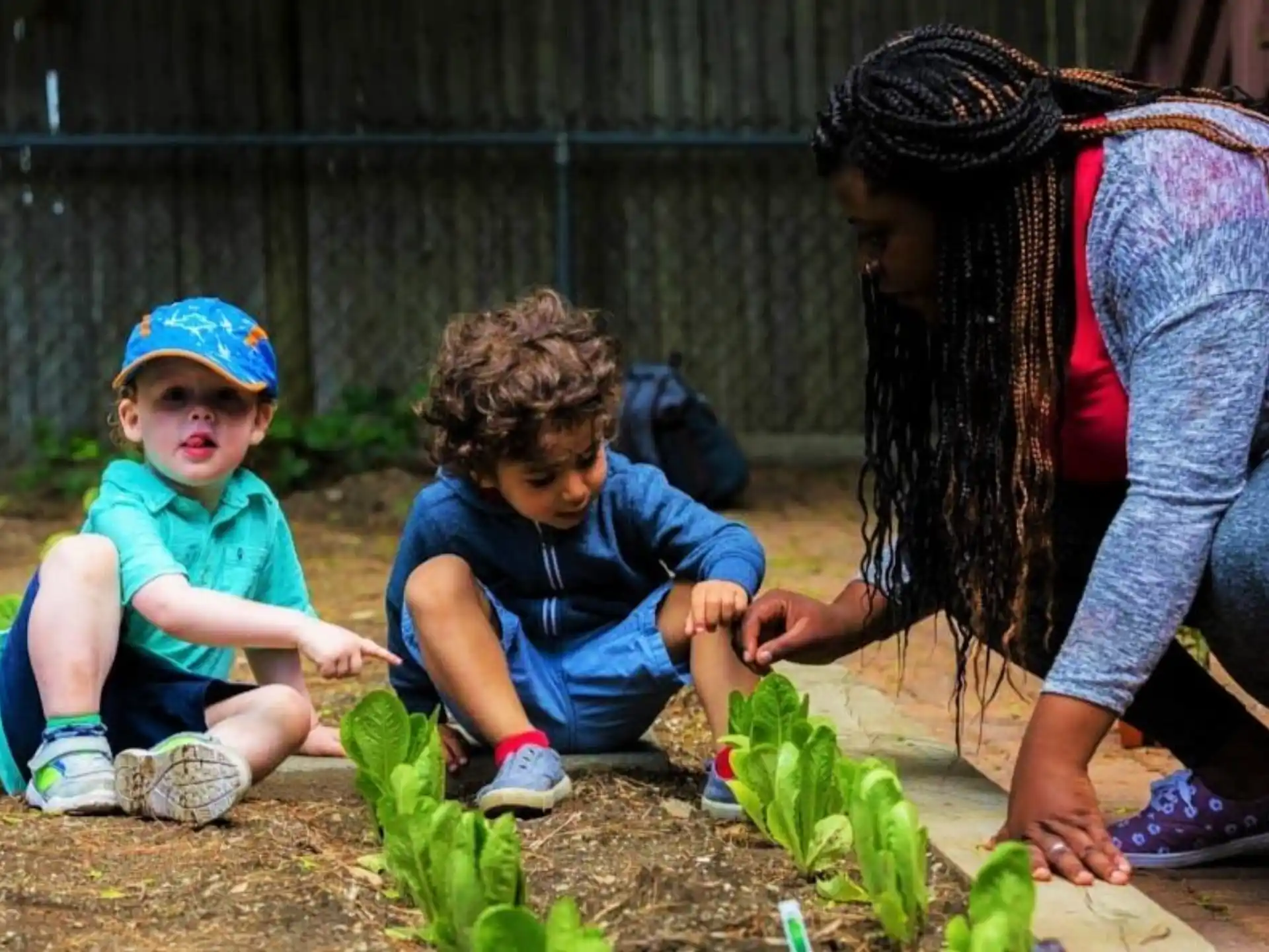 a person and two children planting plants
