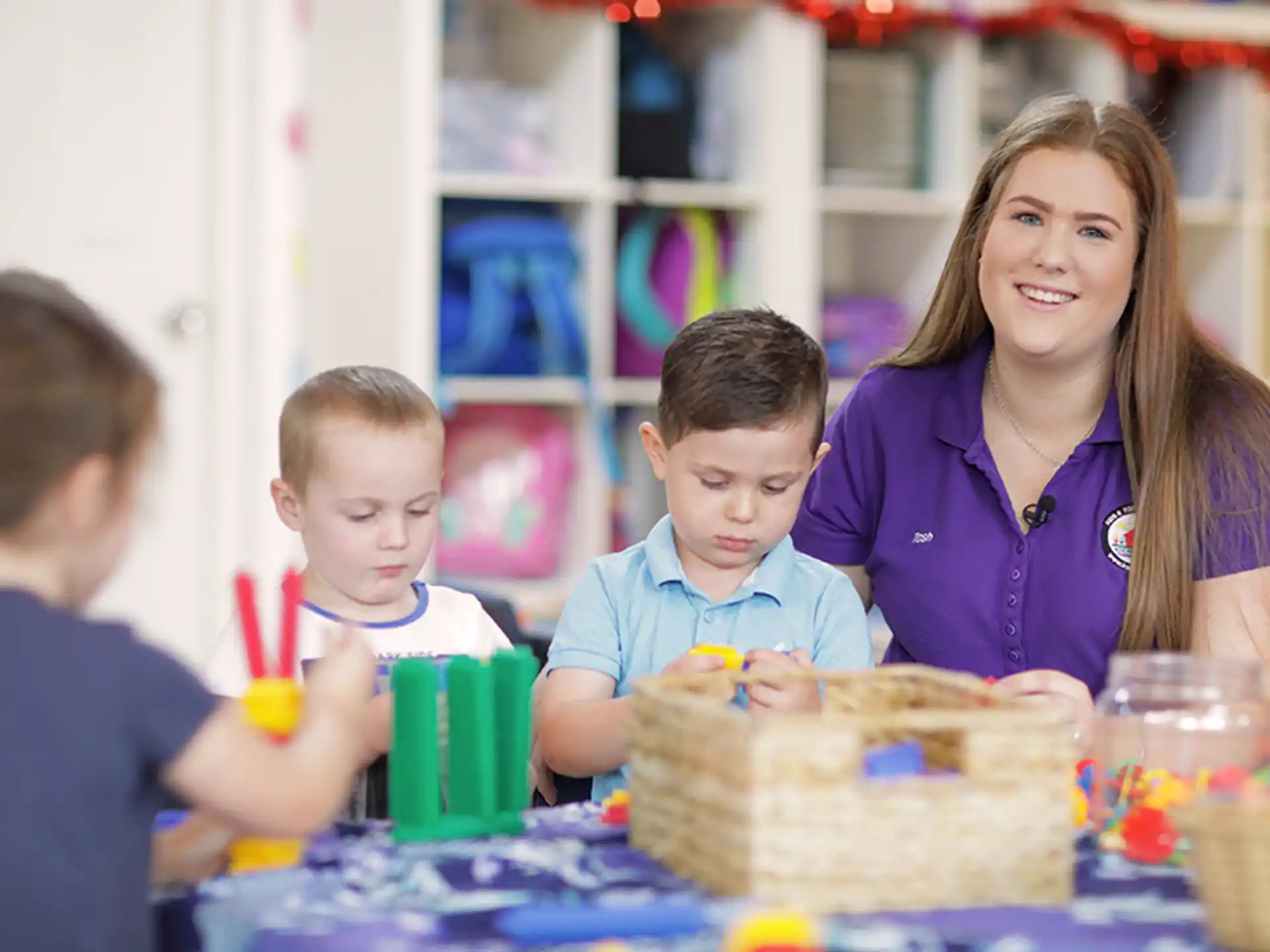 a person and two children sitting at a table with a cake