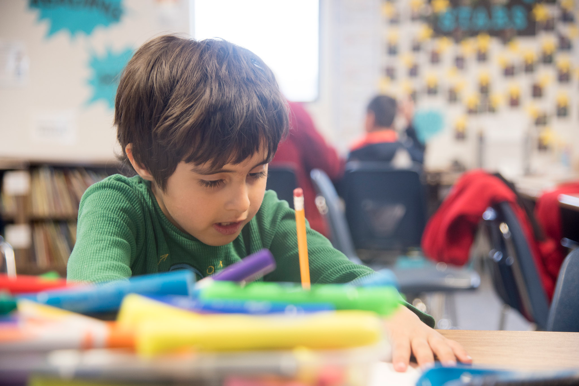 a young boy sitting at a desk