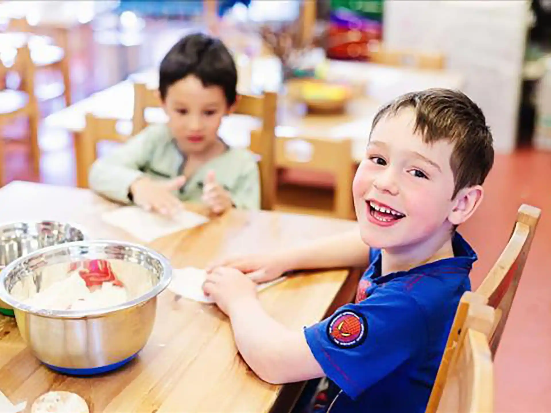a couple of boys sitting at a table with food
