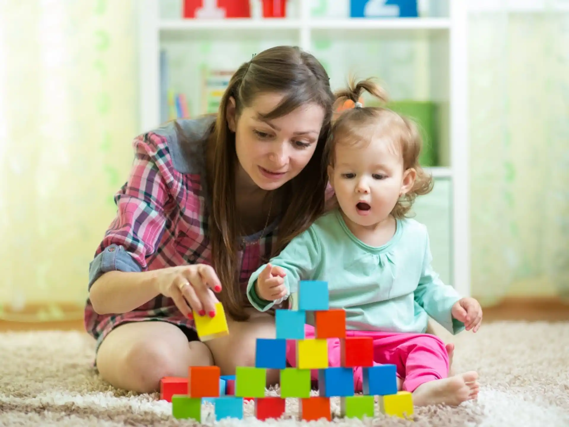 a person and a baby playing with a toy