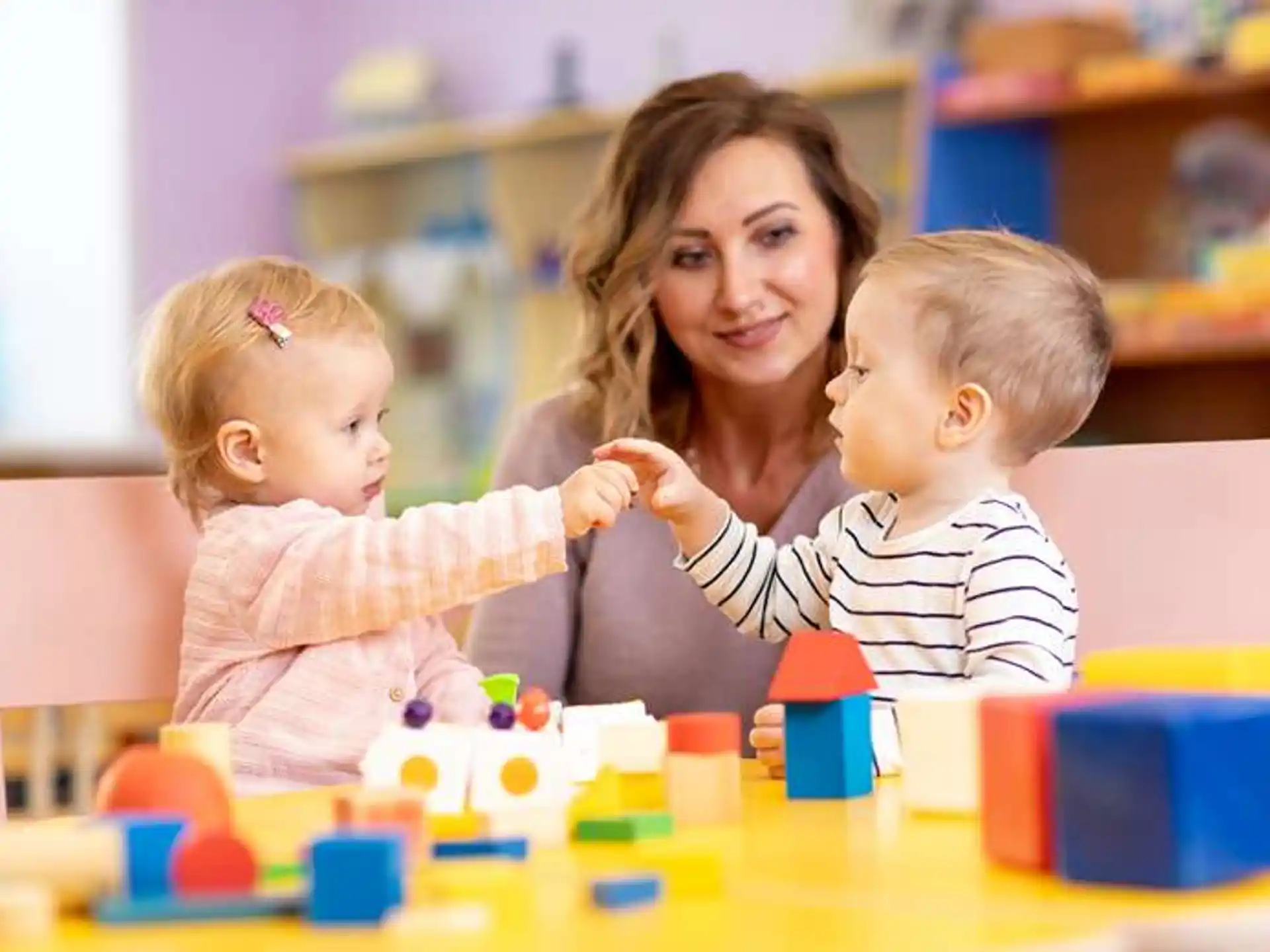 a person and two children playing with toys