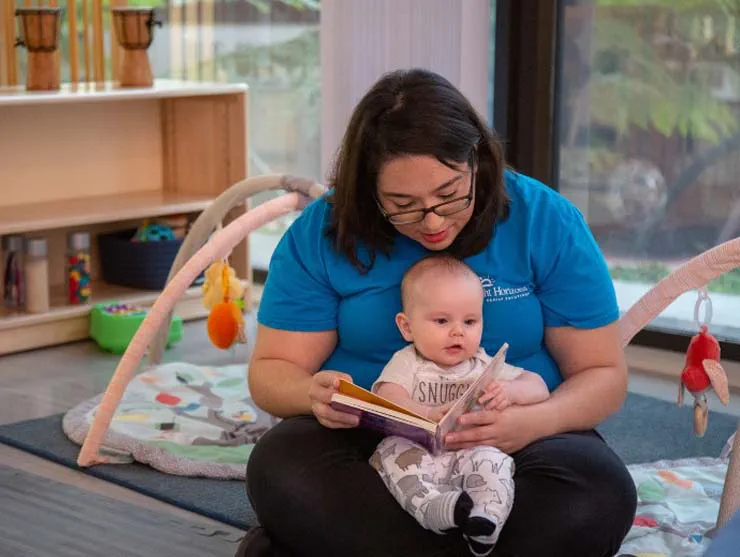 a person reading a book to a baby