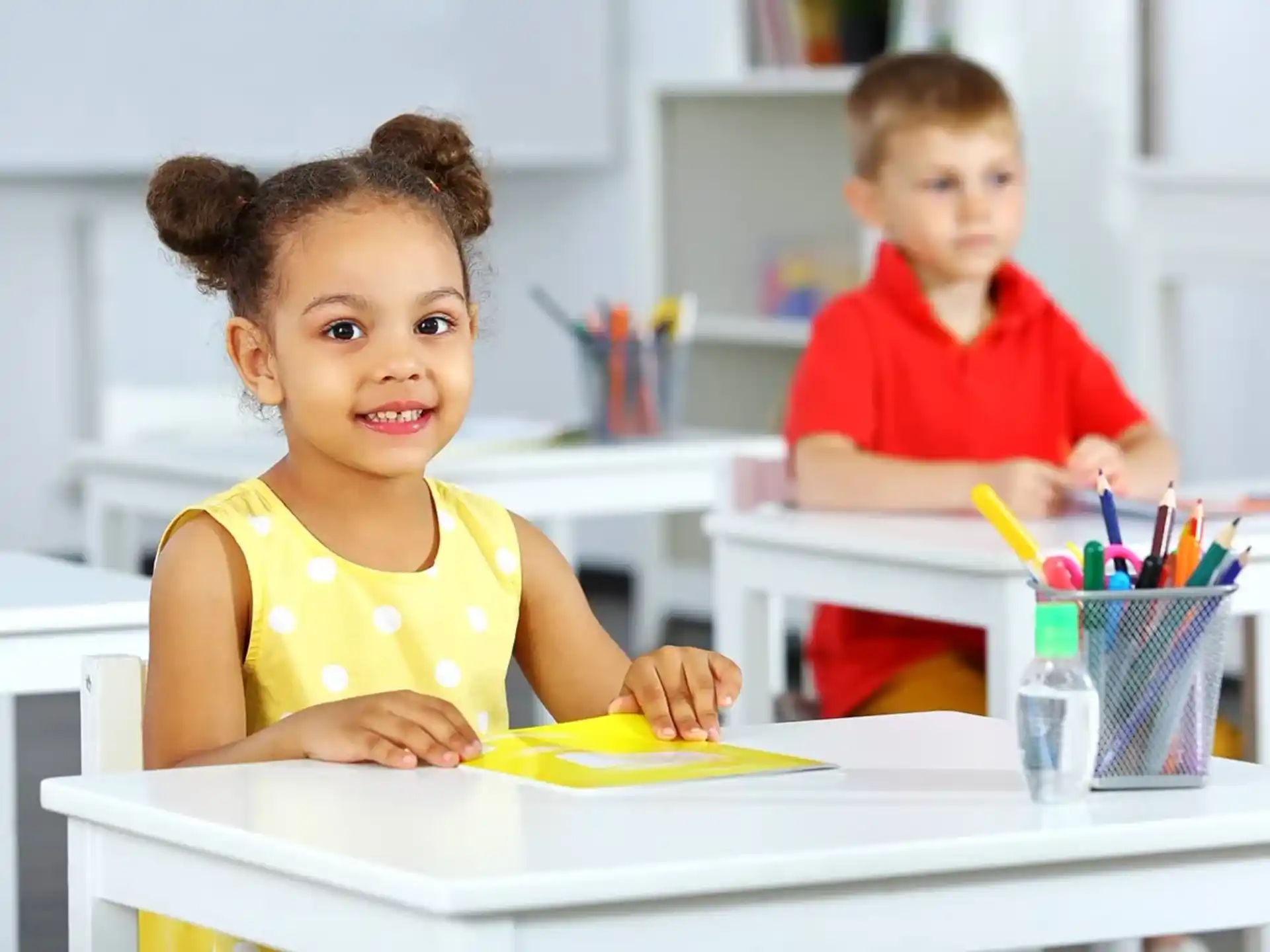 a young girl and a young boy sitting at a table