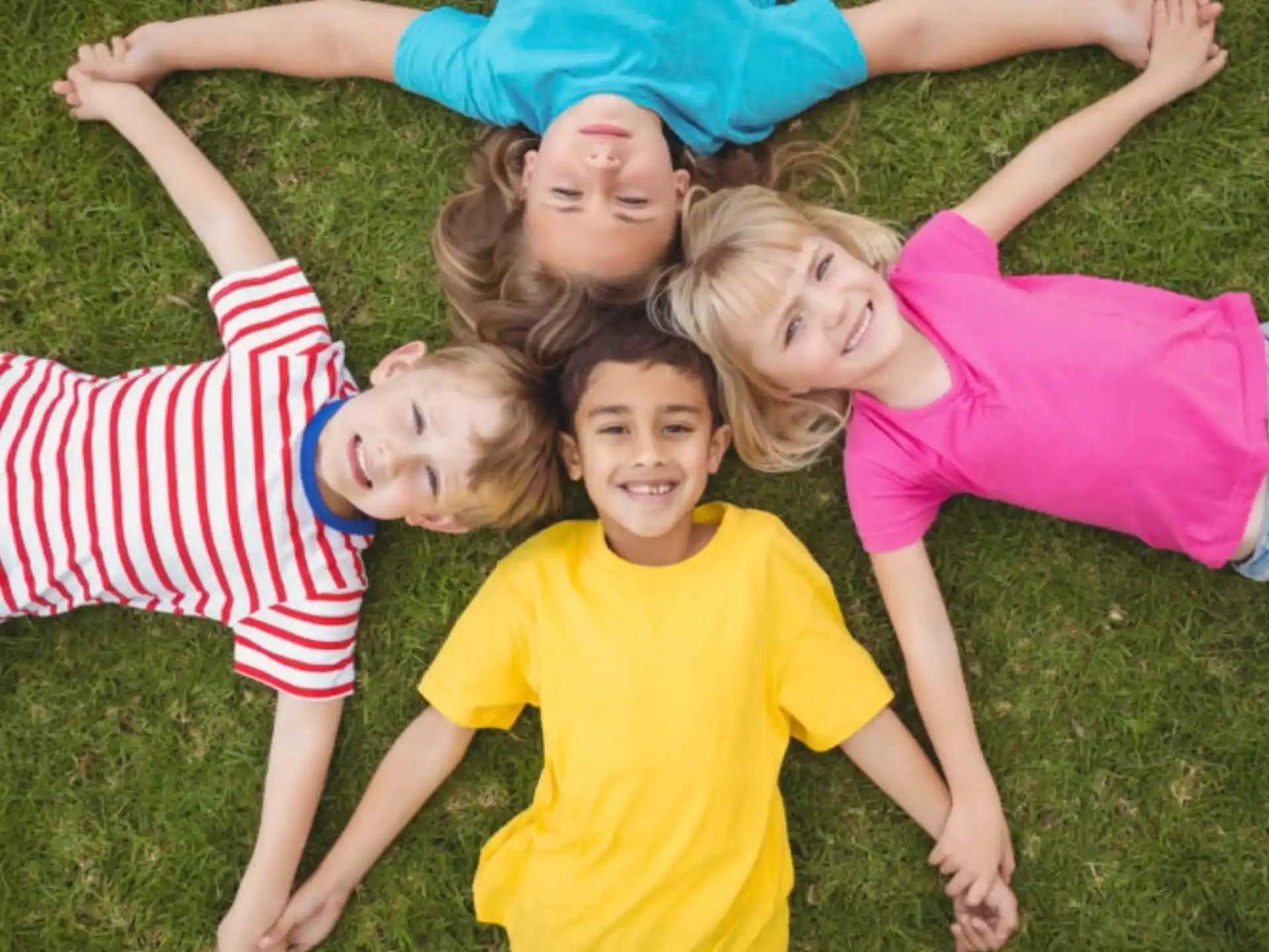 a group of children lying on the grass