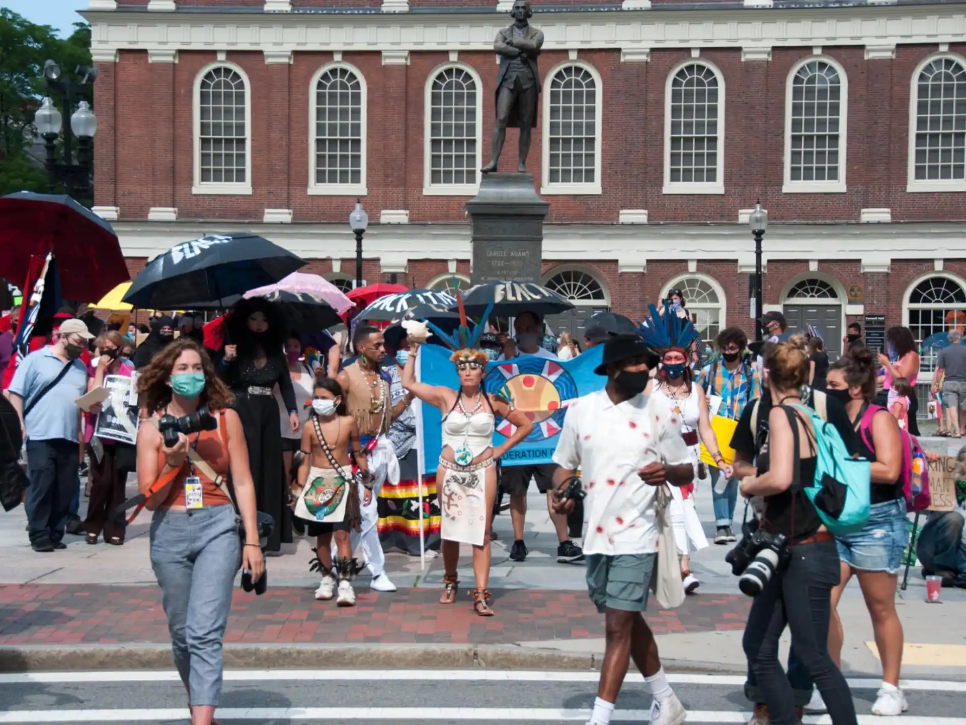 a group of people walking in the street with umbrellas