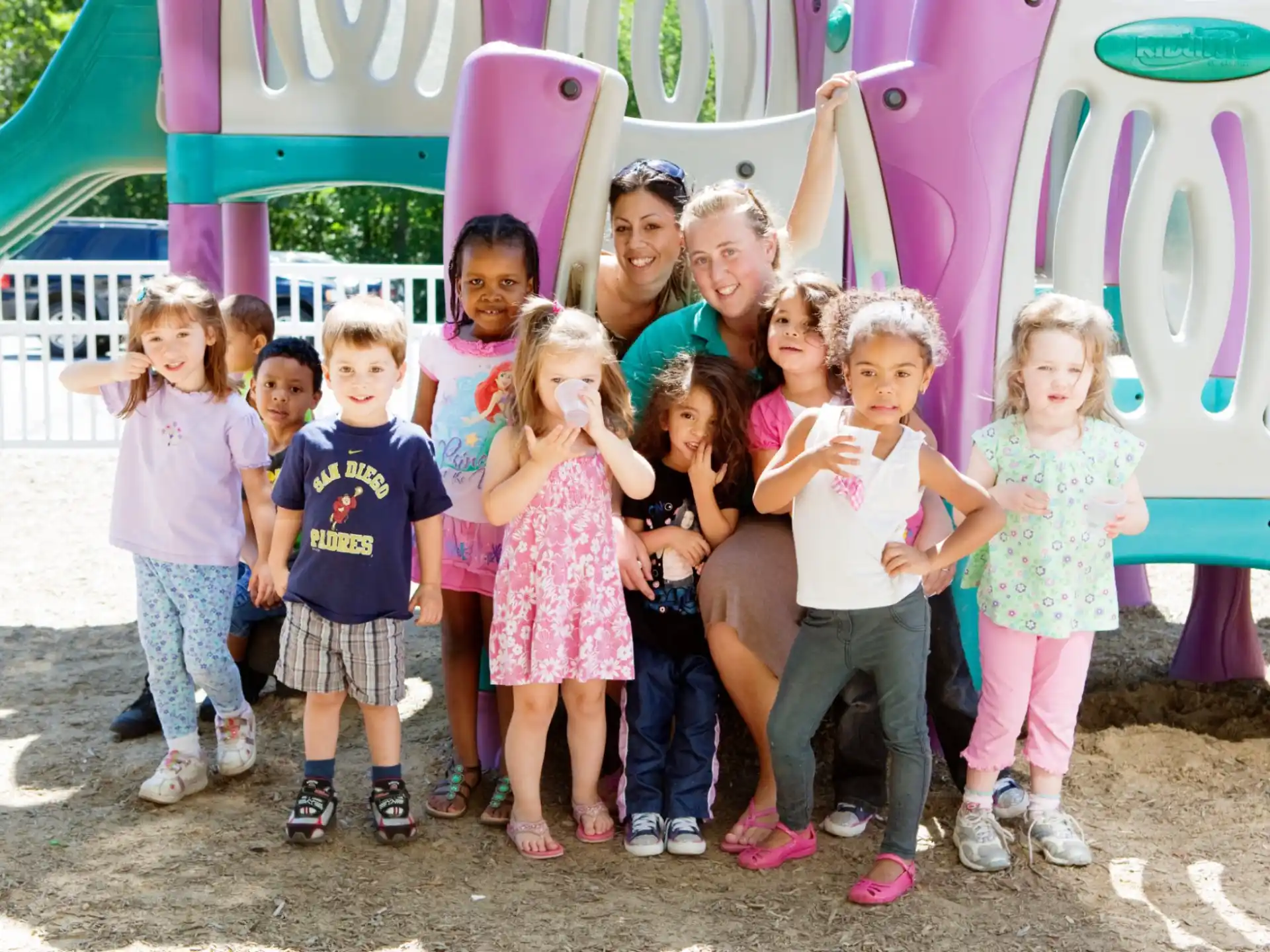 a group of children posing for a photo in front of a sign