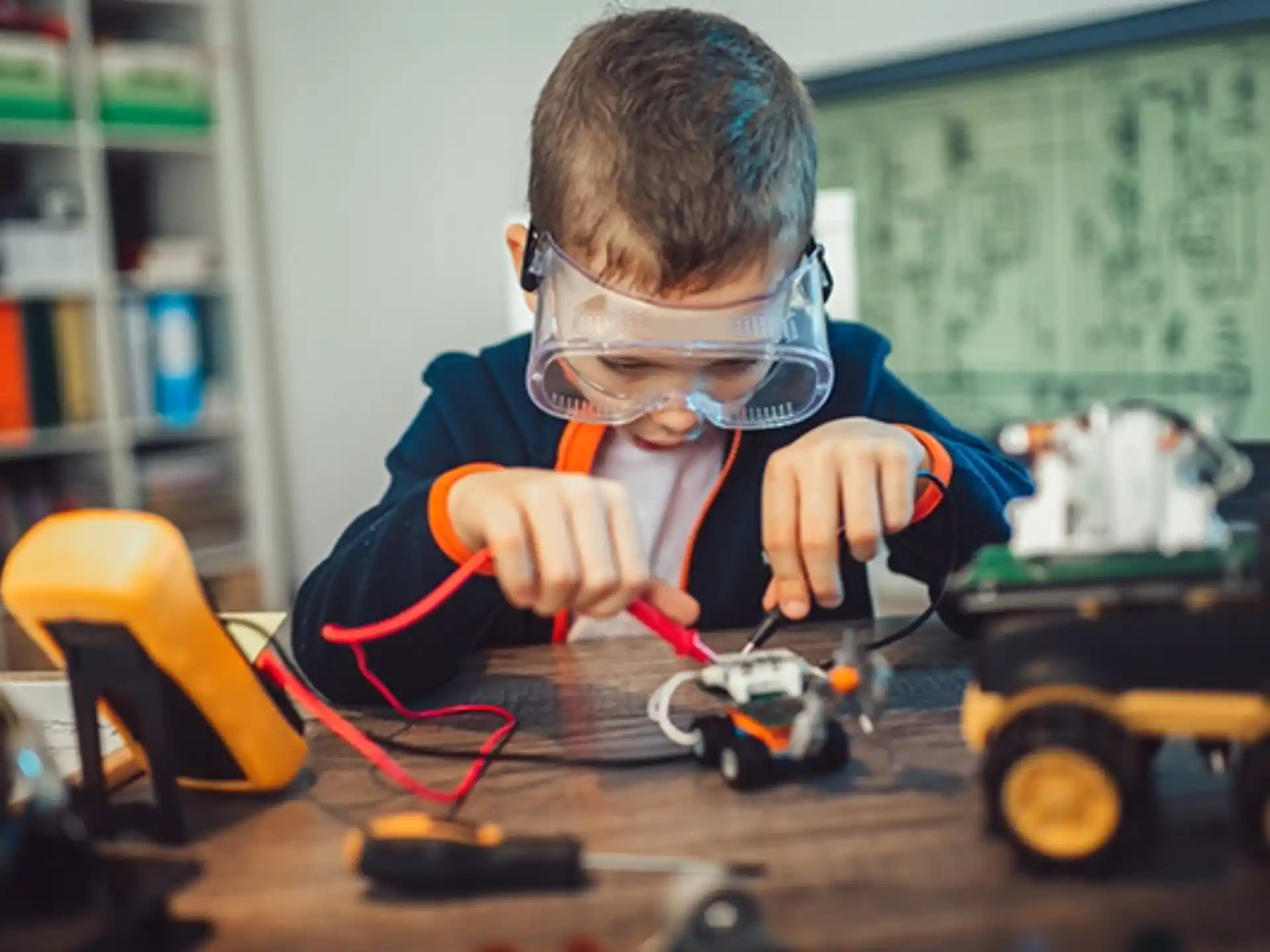a person wearing safety goggles and working on a toy car