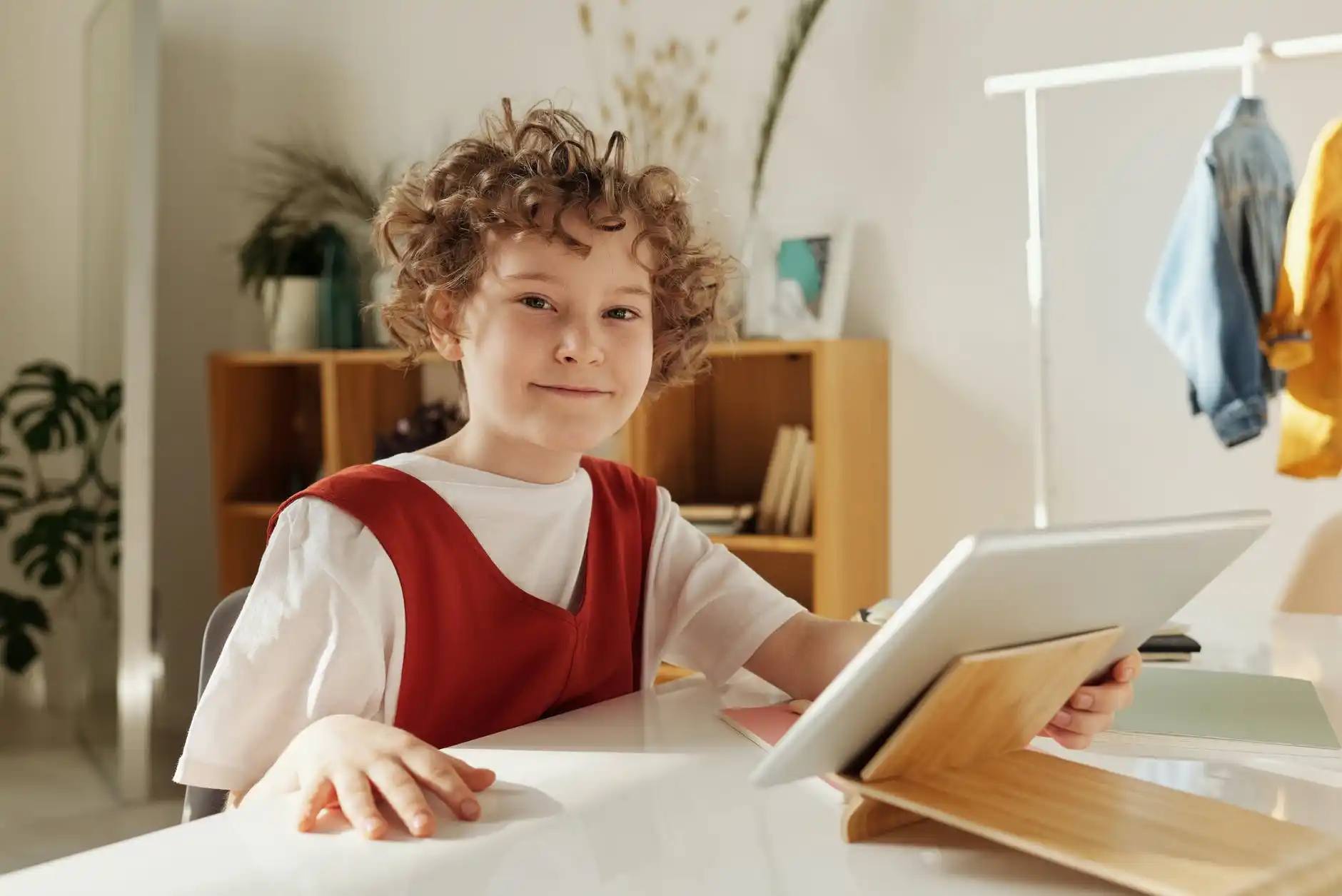 a young boy sitting at a table with a laptop