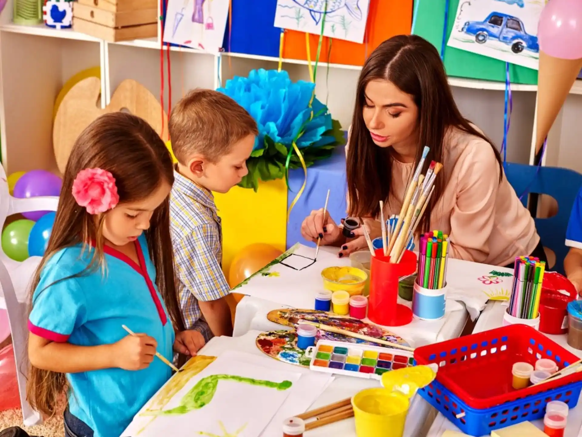 a person and two children painting