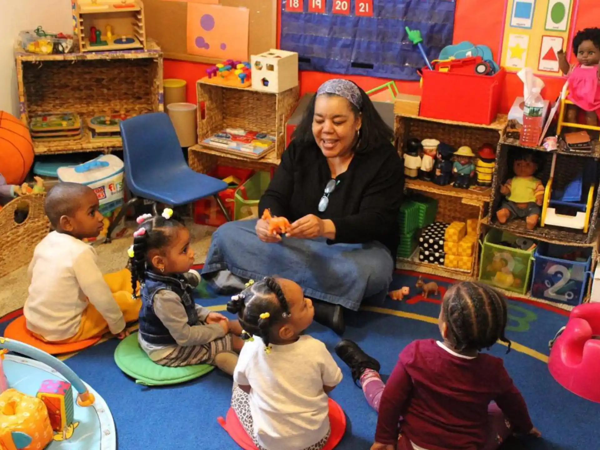 a person and several children sitting on the floor