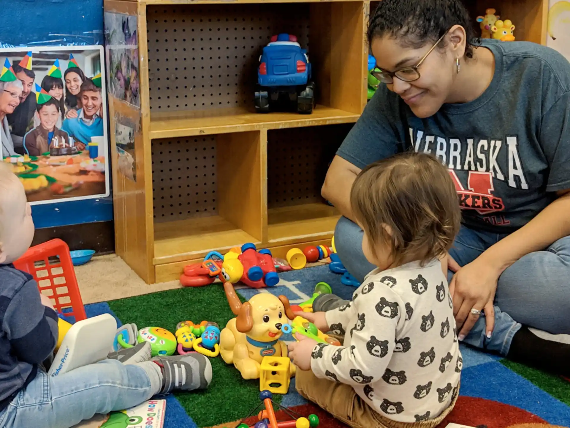 a person and two children playing with toys