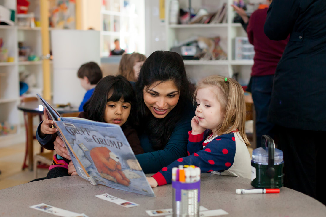 a person reading a book to a group of children